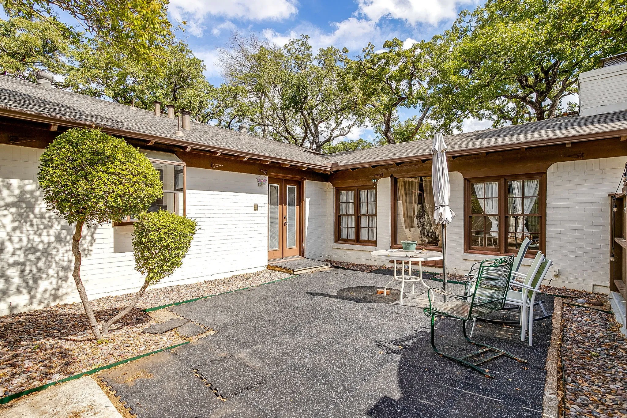 White brick exterior with a brown fascia and shingled roof