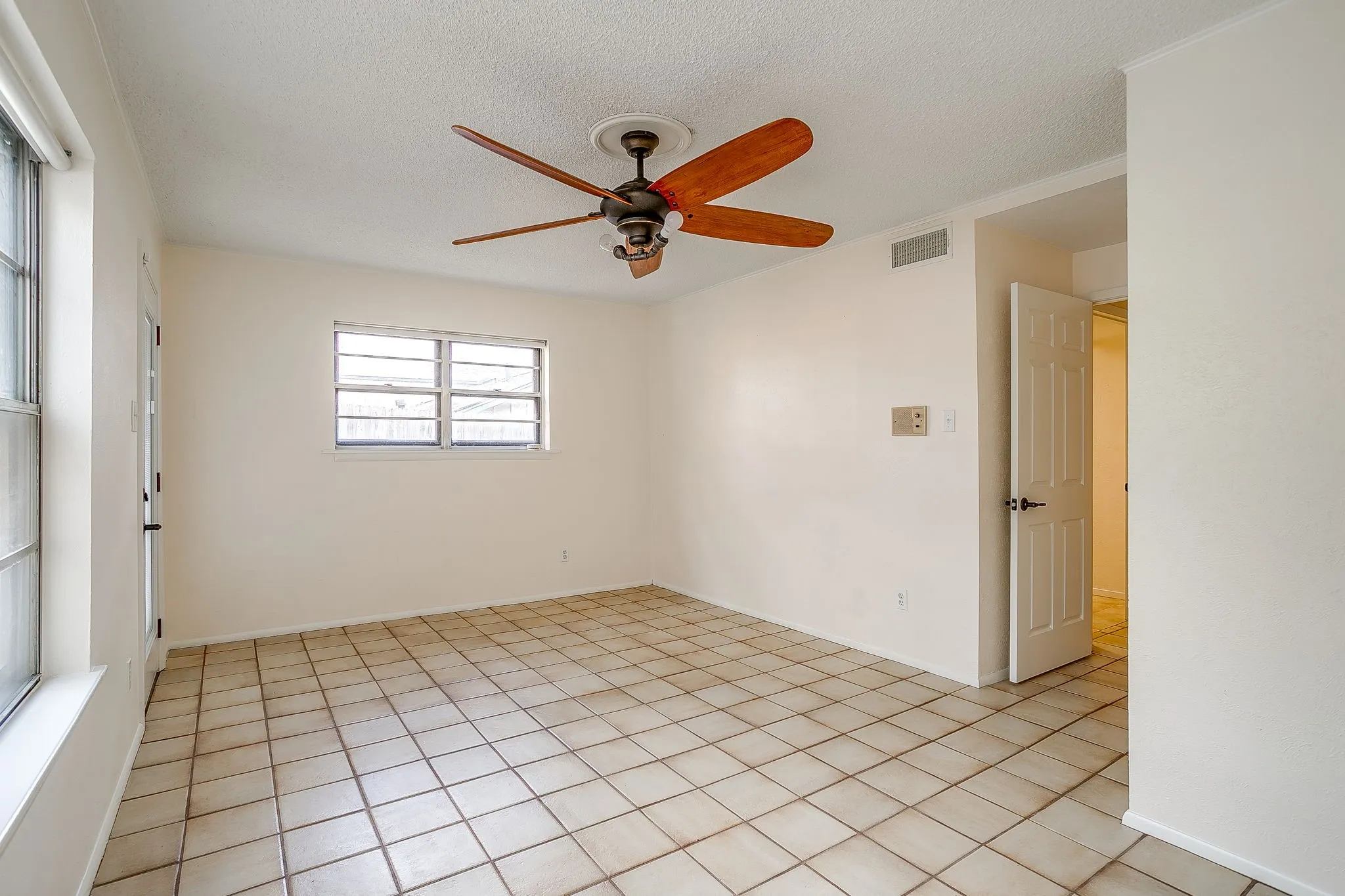 Neutral color palette with tile flooring and a ceiling fan