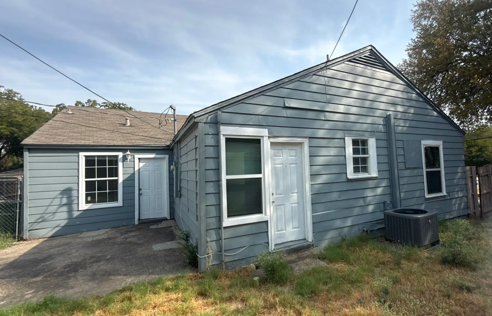Gray siding exterior with white trim windows and doors