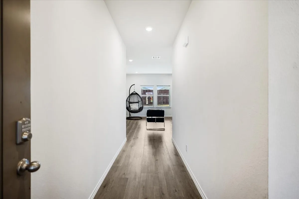 Entryway featuring wood-finish flooring, recessed lighting, and a digital keyless door lock