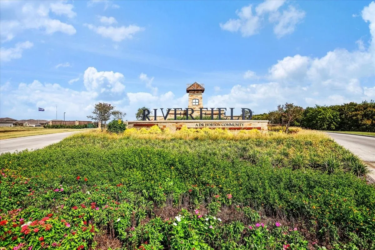 Community entrance with stone signage and prominent tower element