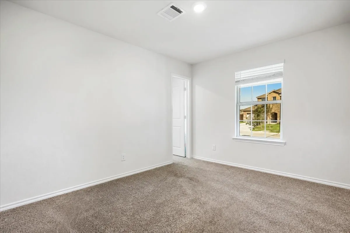 Neutral wall paint, carpeted flooring, window with blinds, recessed lighting, and a white interior door