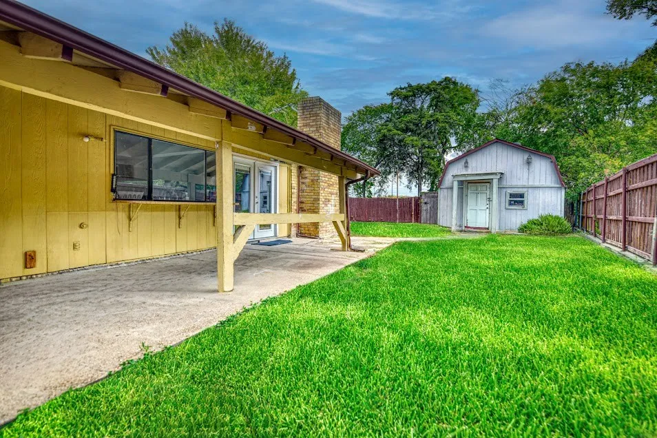 Expansive concrete patio with an exterior serving window and double glass panel doors