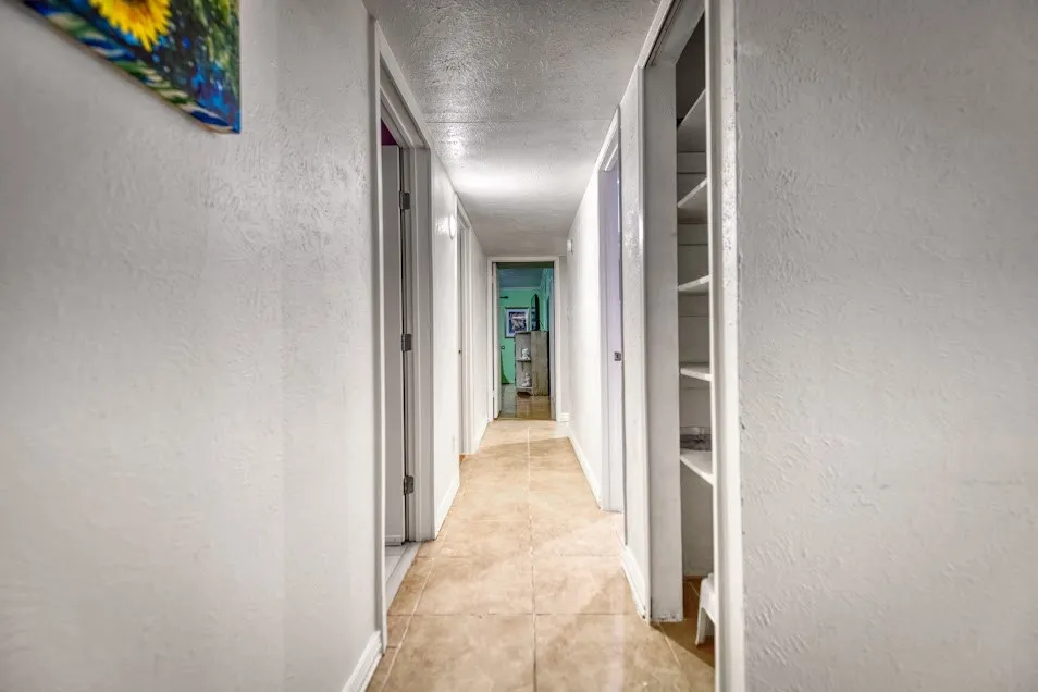 Hallway with tiled flooring and integrated shelving