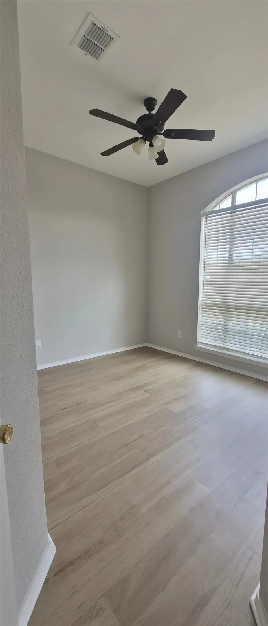 Wood-finish flooring throughout, complemented by a ceiling fan with integrated lighting