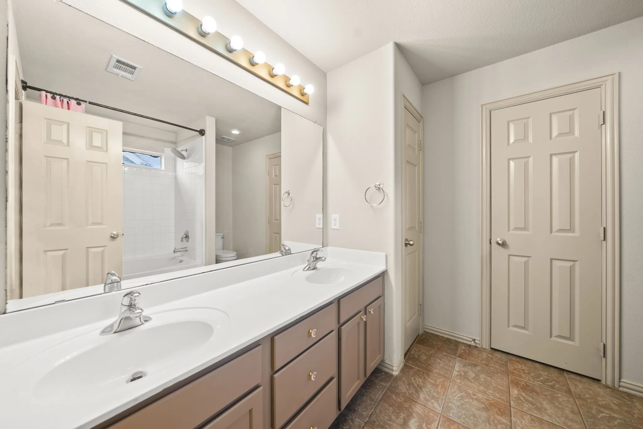 Dual vanity with integrated sinks, chrome faucets, and under-cabinet storage