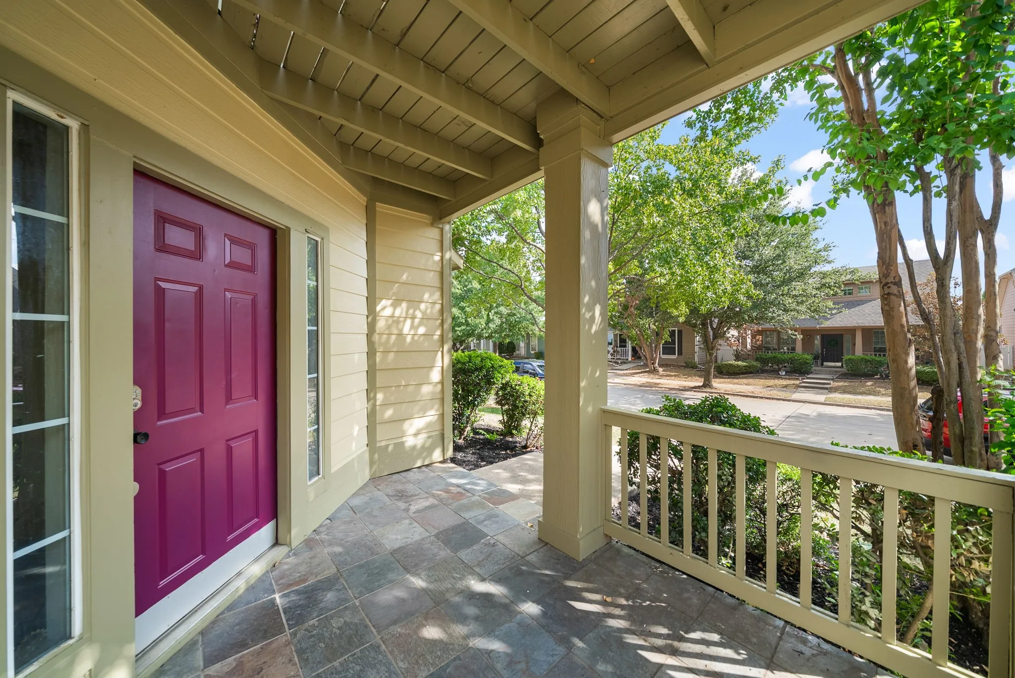 Covered front porch featuring a paneled entry door, sidelight windows, and tile flooring