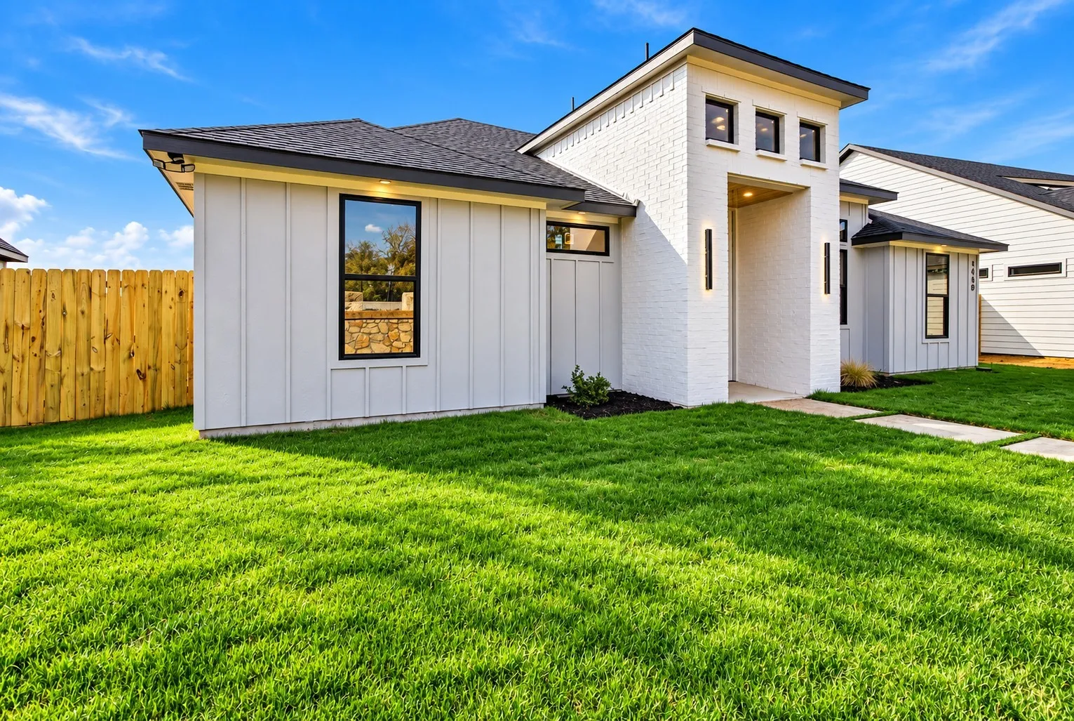 Modern exterior with white brick, vertical panel siding, and dark trim windows