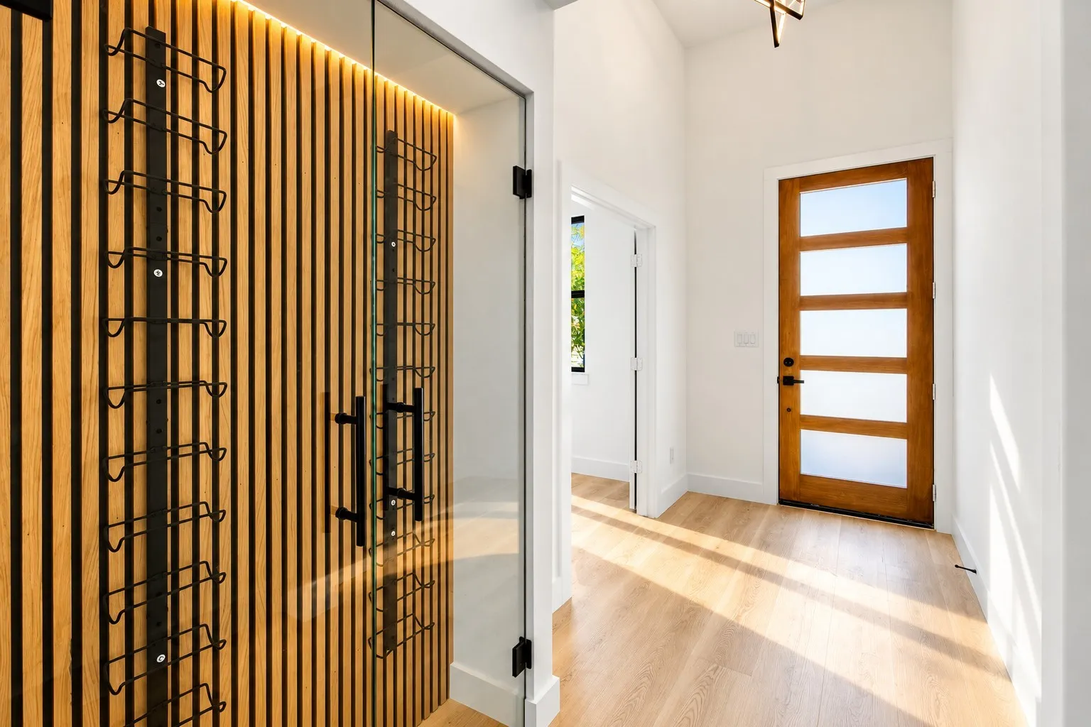 Custom wine storage with vertical wood-finish paneling and integrated lighting