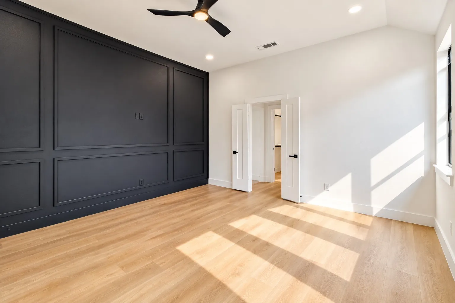 Accent wall with wainscoting details, wood-finish flooring, vaulted ceiling, recessed lighting, and a ceiling fan