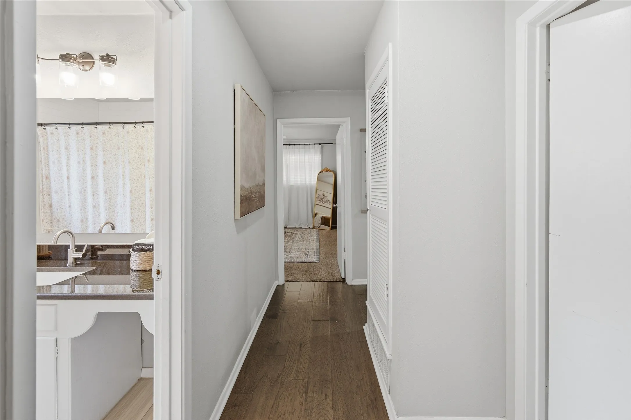 Hallway with wood-finish flooring and white walls