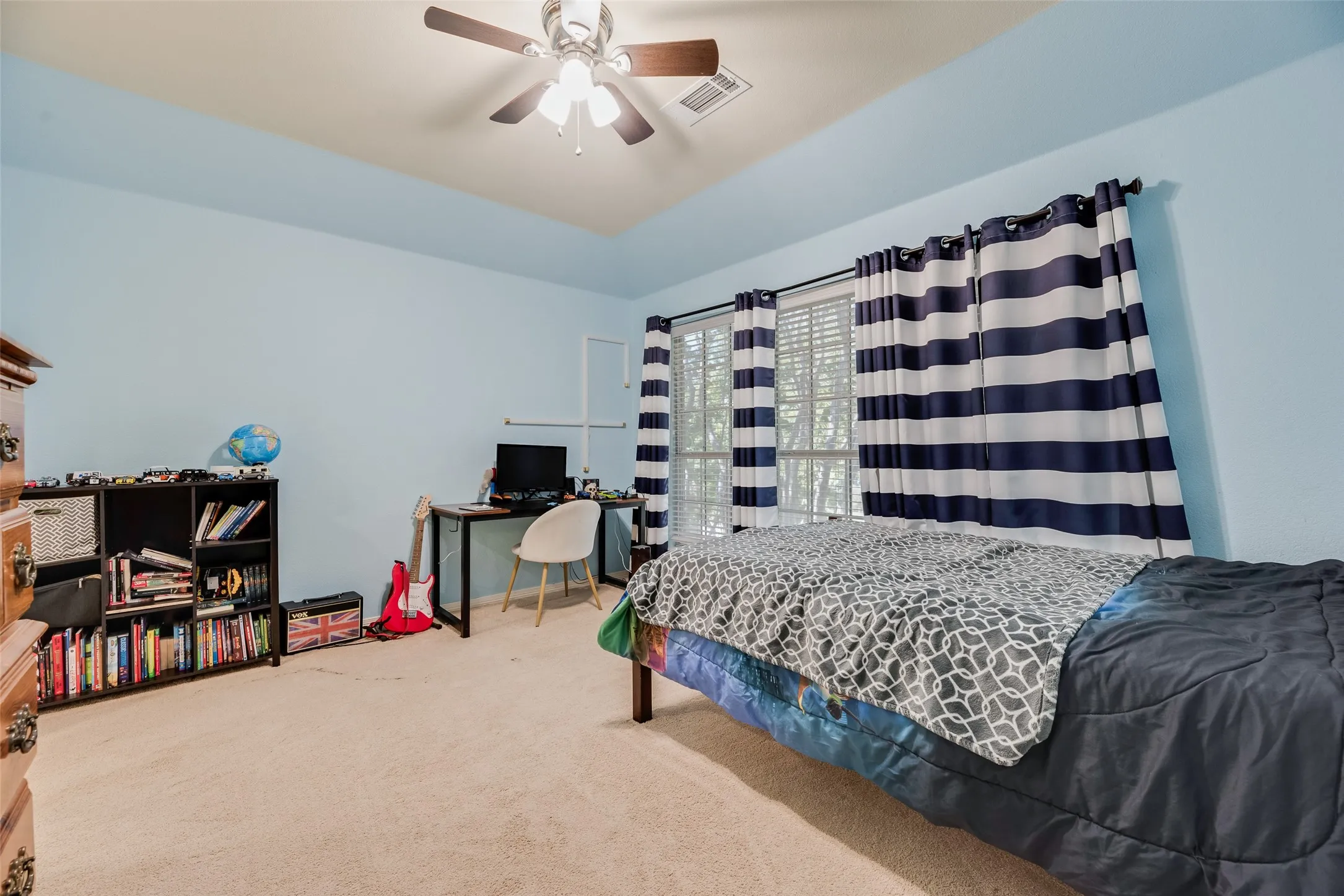 Carpeted room featuring a ceiling fan, recessed ceiling, and window with blinds