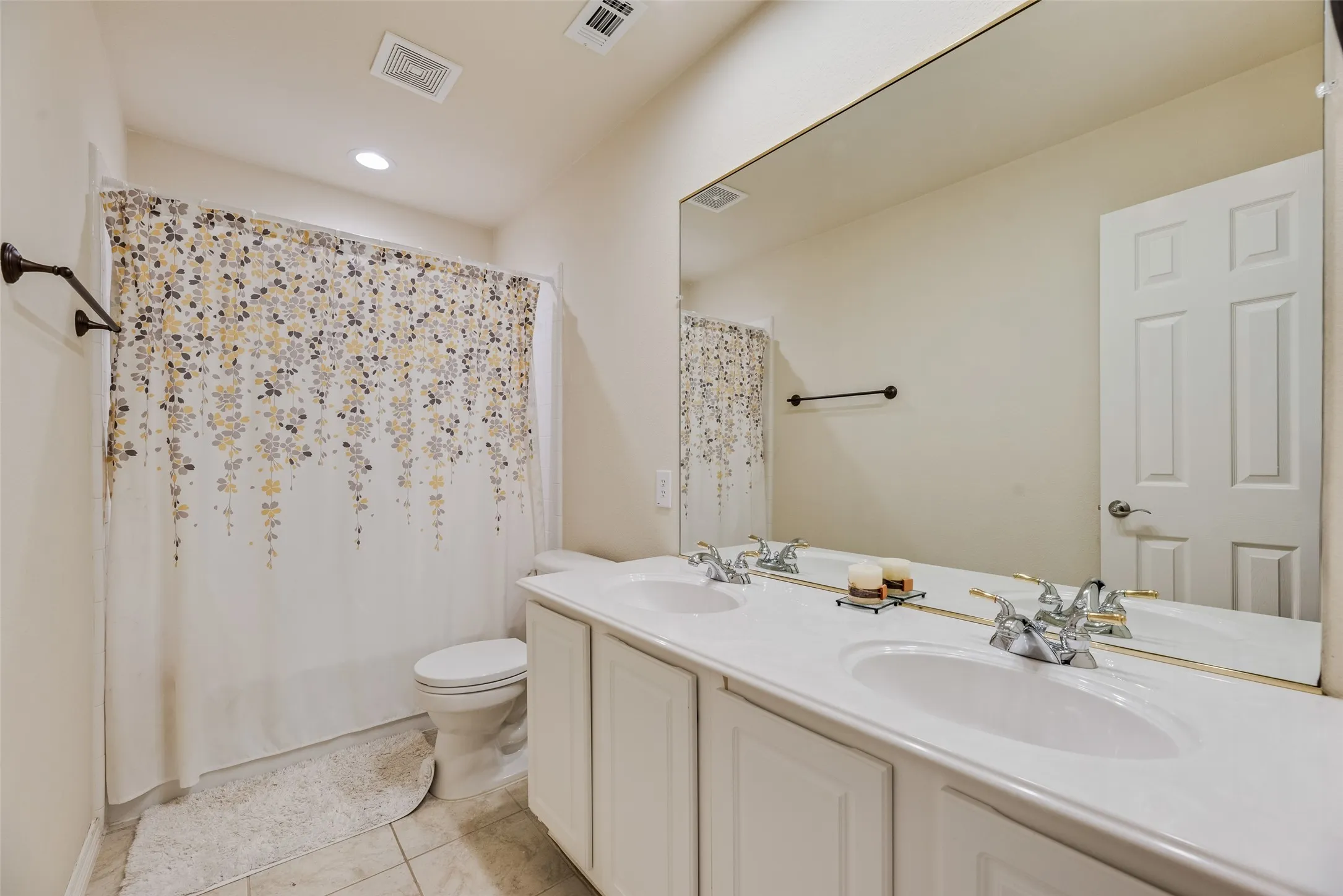 Dual vanity with integrated sinks, framed mirror, and tile flooring