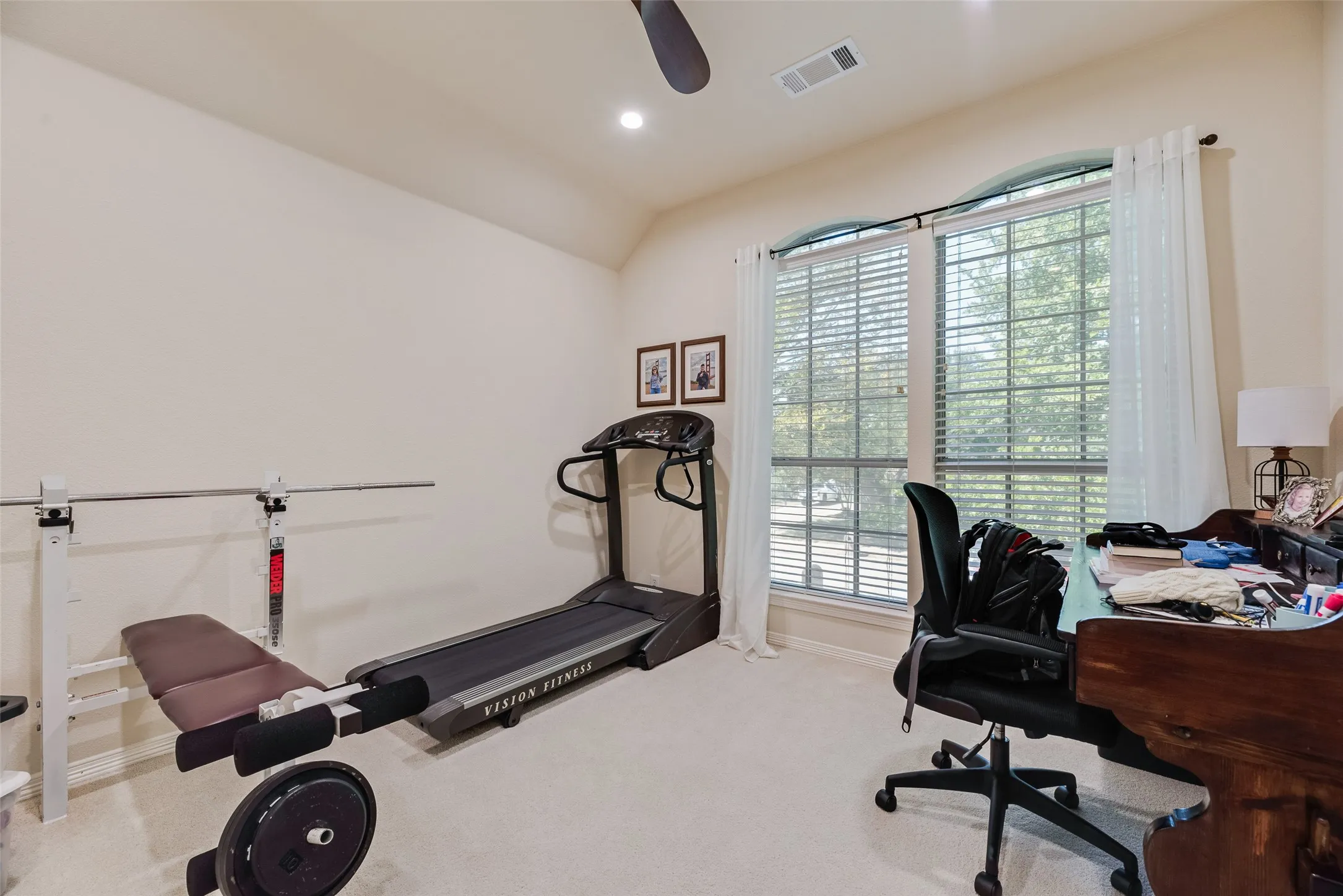 Carpeted interior space with a ceiling fan, recessed lighting, and a large window with blinds and sheer curtains