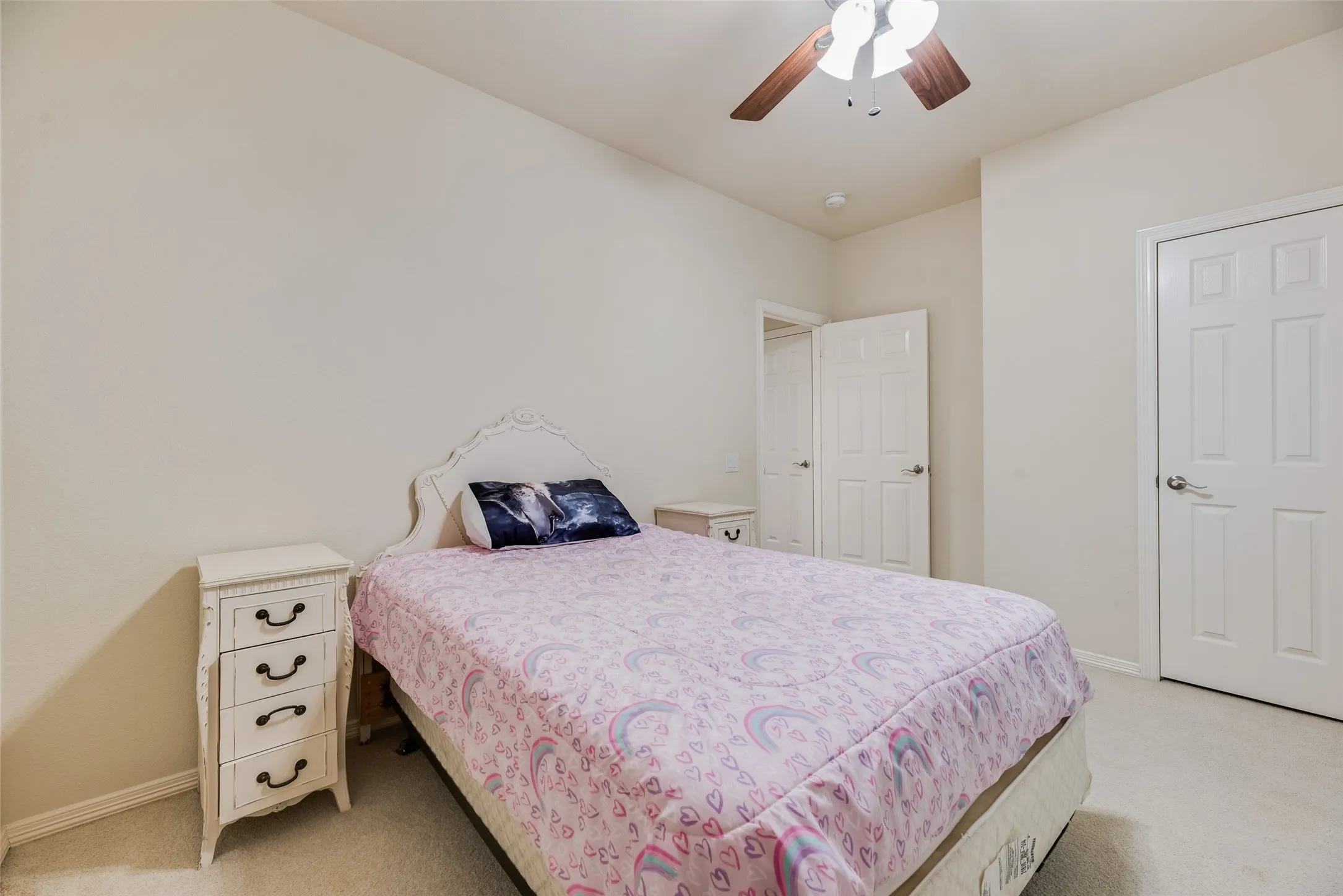 Neutral wall paint, ceiling fan with wood-finish blades, and white paneled doors