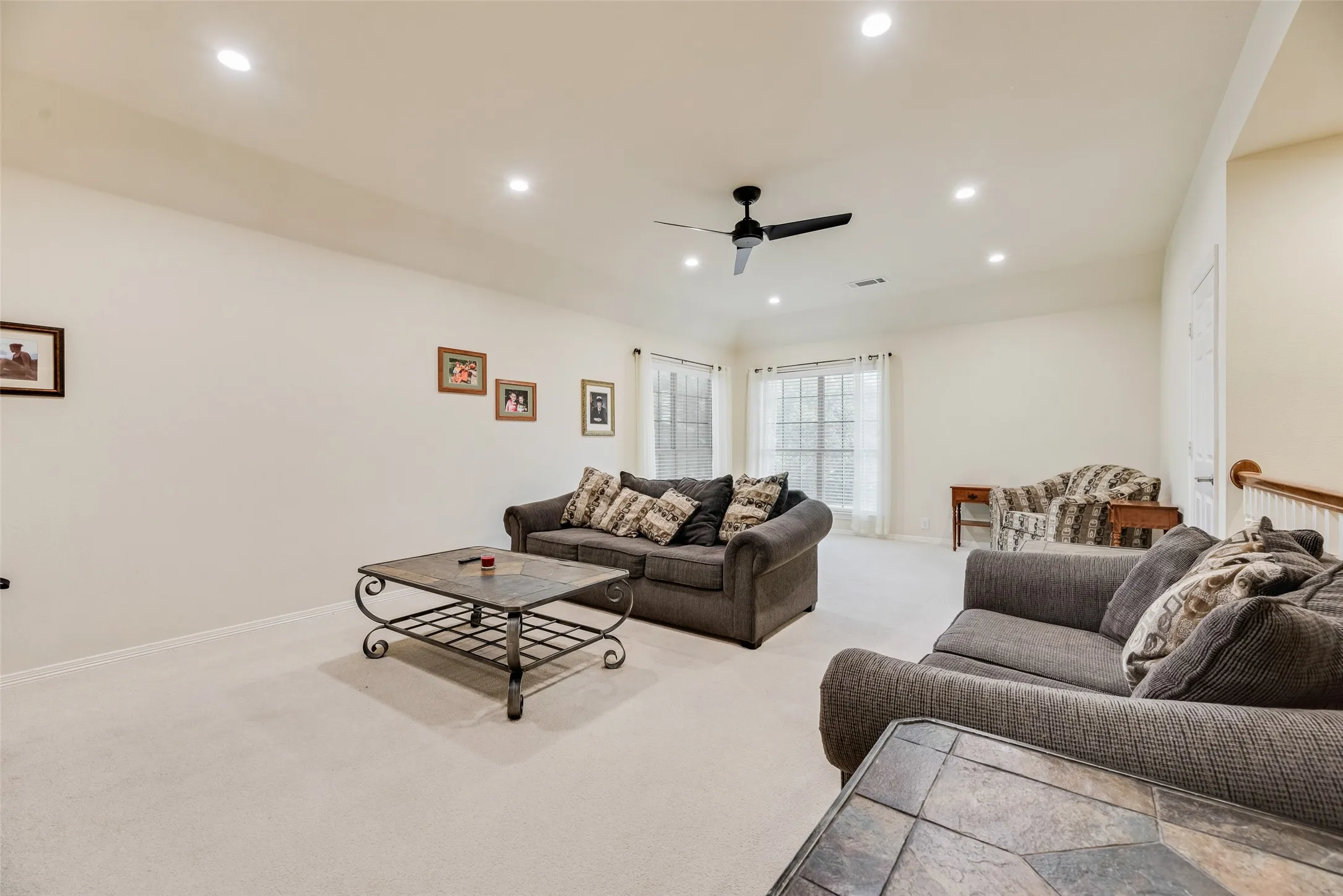 Carpeted flooring, recessed lighting, ceiling fan, and multiple windows with vertical blinds
