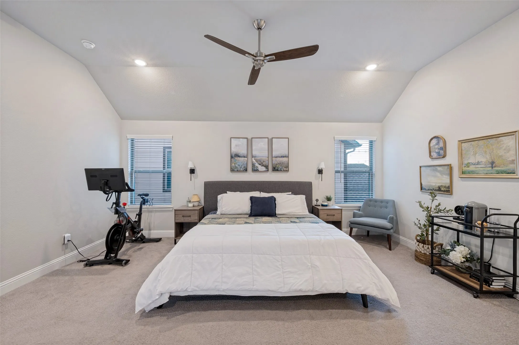 Primary bedroom feature vaulted ceiling with recessed lighting and a ceiling fan, carpeted flooring, and two windows with blinds