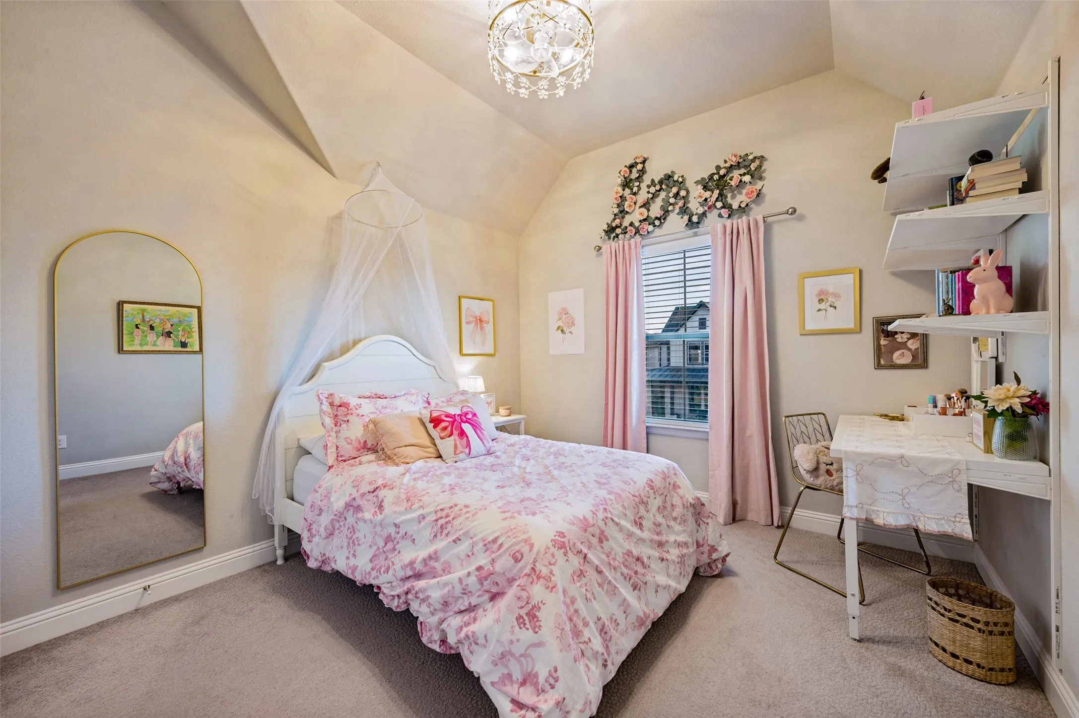 Vaulted ceiling with an ornate chandelier, window with horizontal blinds and light-toned carpeting