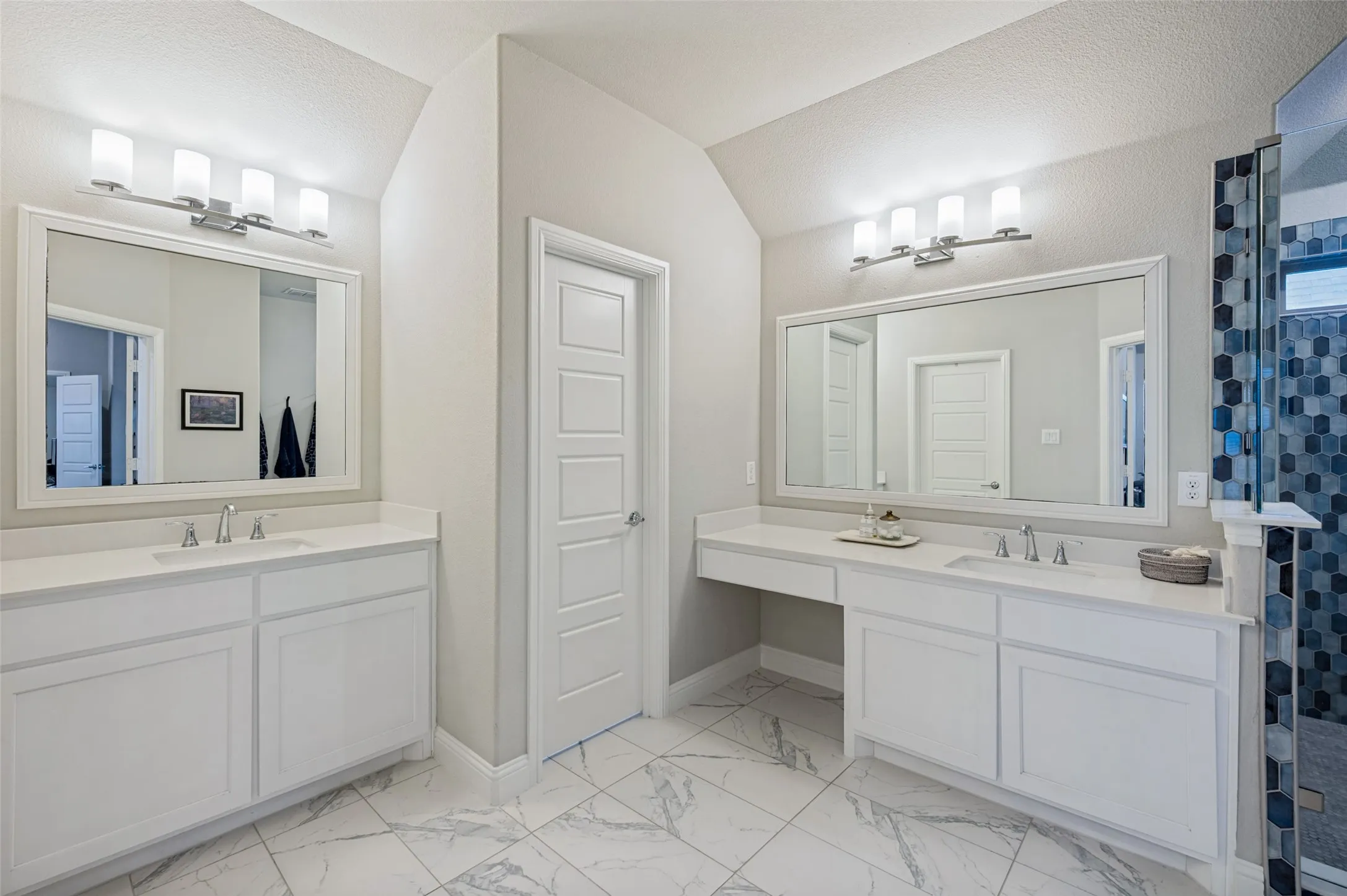 Dual vanity sinks with white cabinetry, polished chrome fixtures, and stone countertops