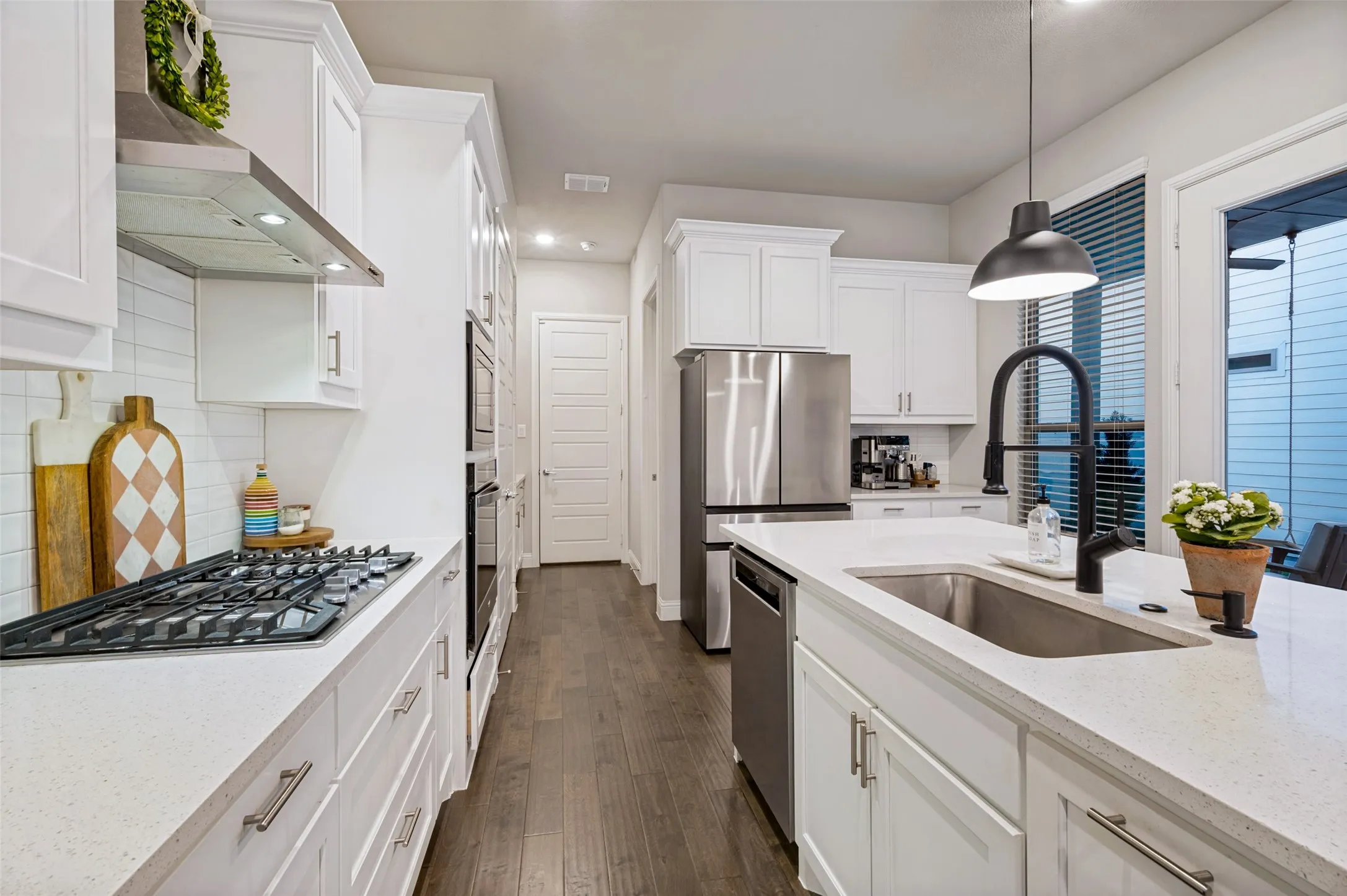 The kitchen features a stainless steel gas cooktop, built-in microwave and convection oven.