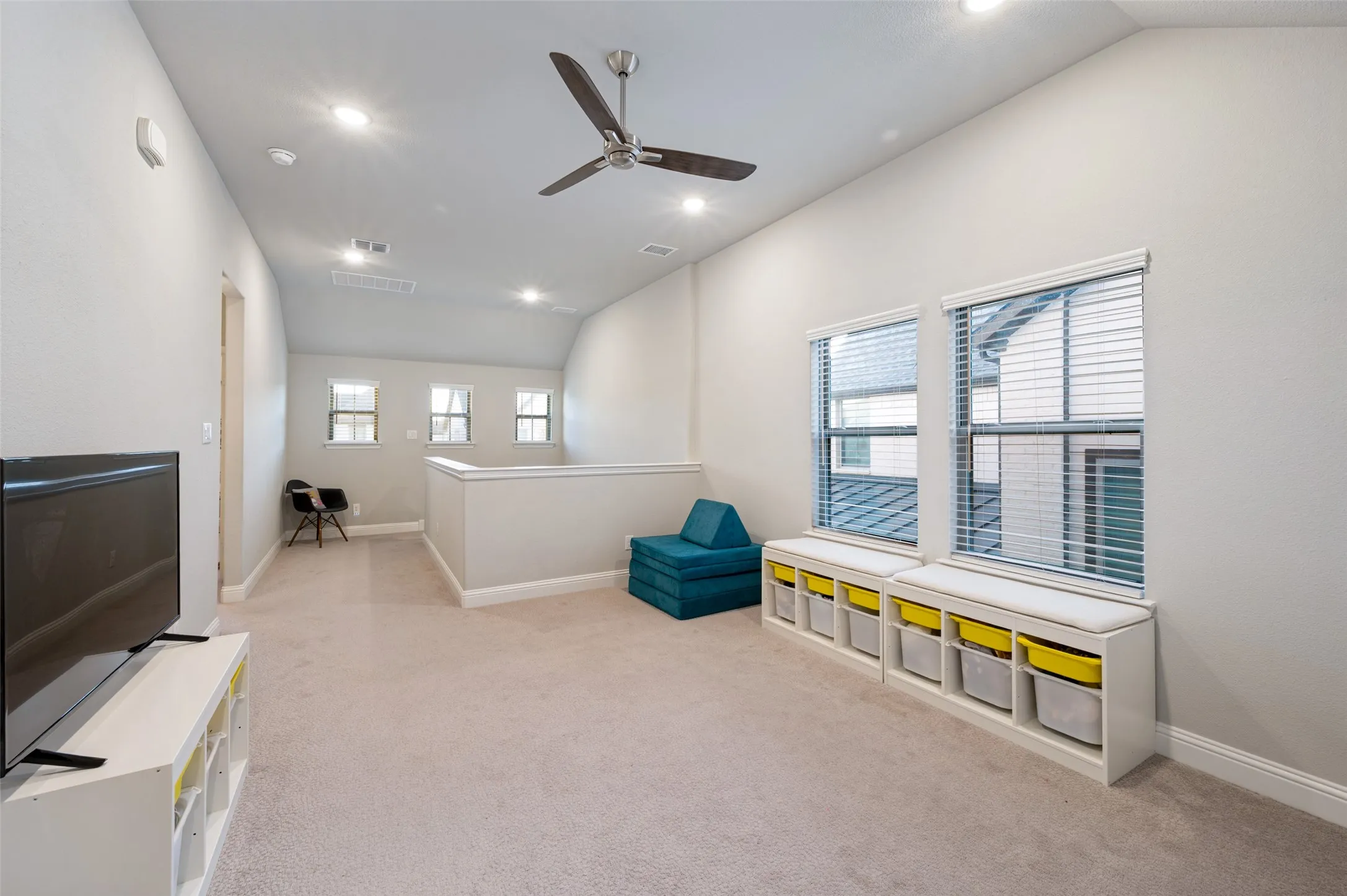 Vaulted ceilings with recessed lighting and a ceiling fan