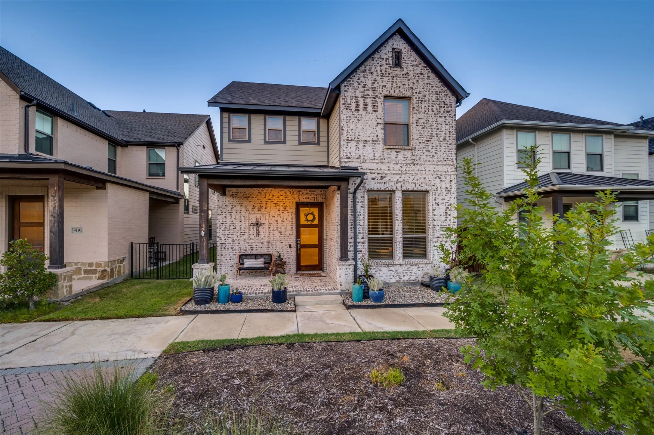 Contemporary two-story residence featuring a brick facade with dark trim accents