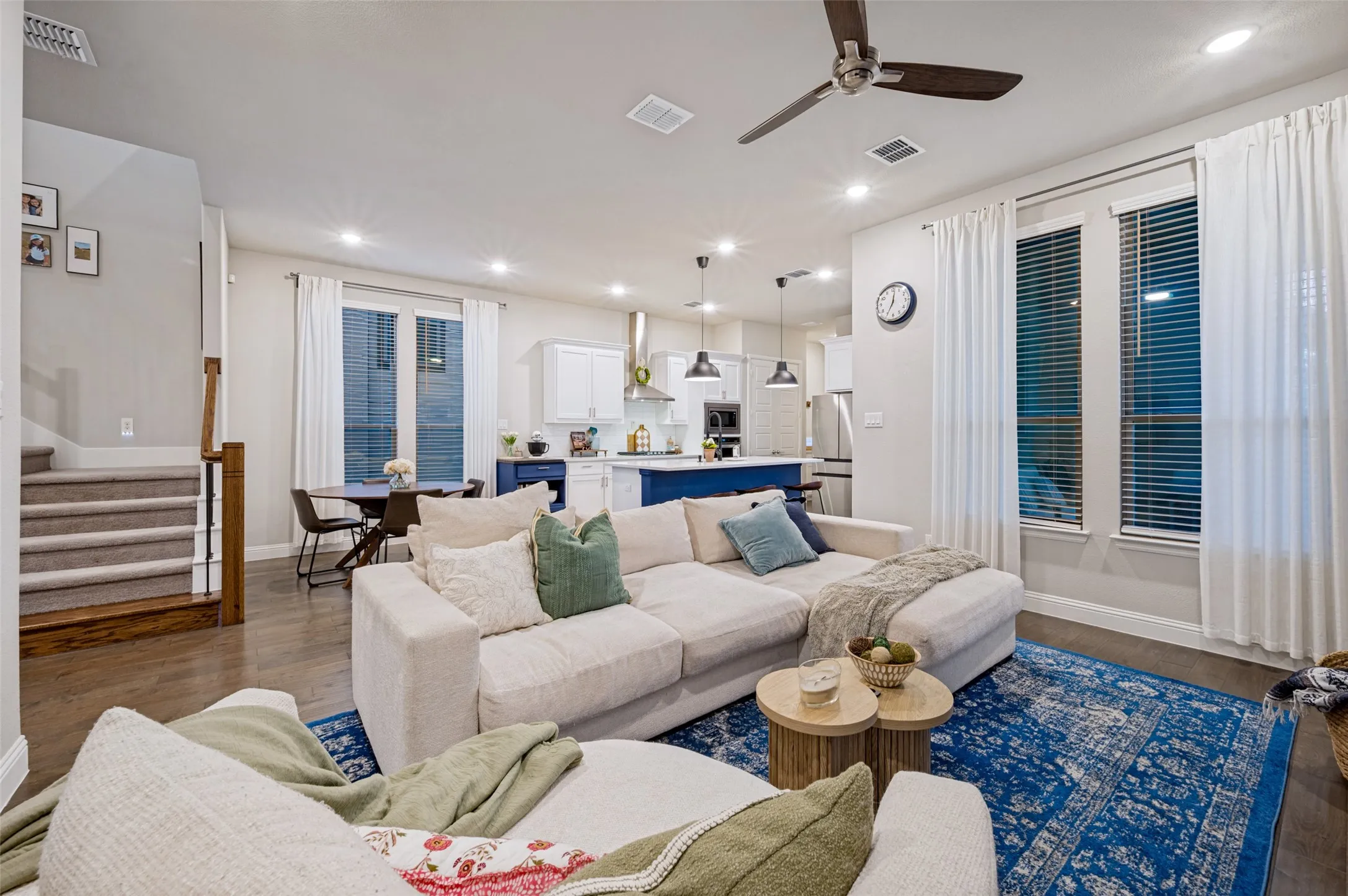 Open-concept living space with wood-finish flooring, a contemporary ceiling fan, and recessed lighting