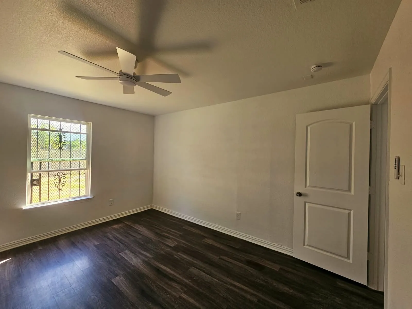 Dark wood-finish flooring with white baseboards