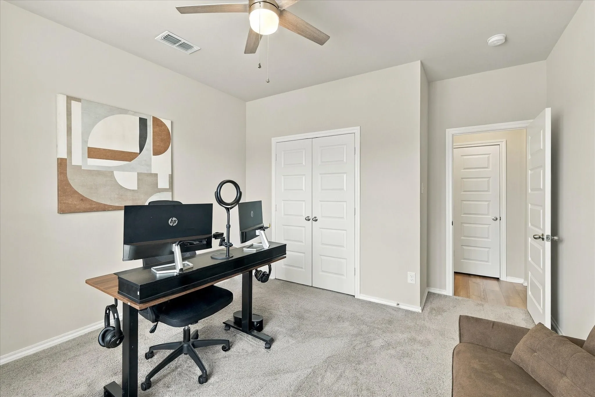 Neutral wall tones with carpet flooring and a ceiling fan