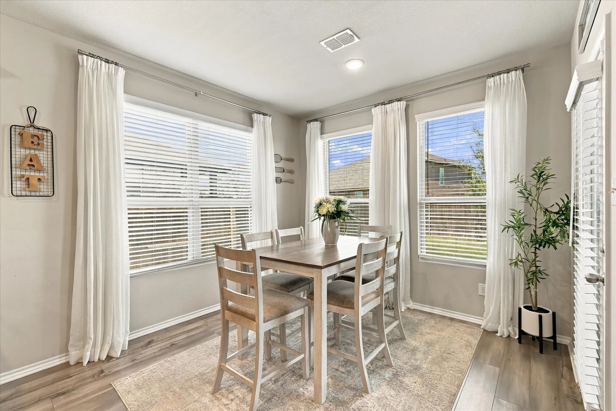Wood-finish flooring, recessed ceiling lighting, light gray wall color, white trim, and white window blinds