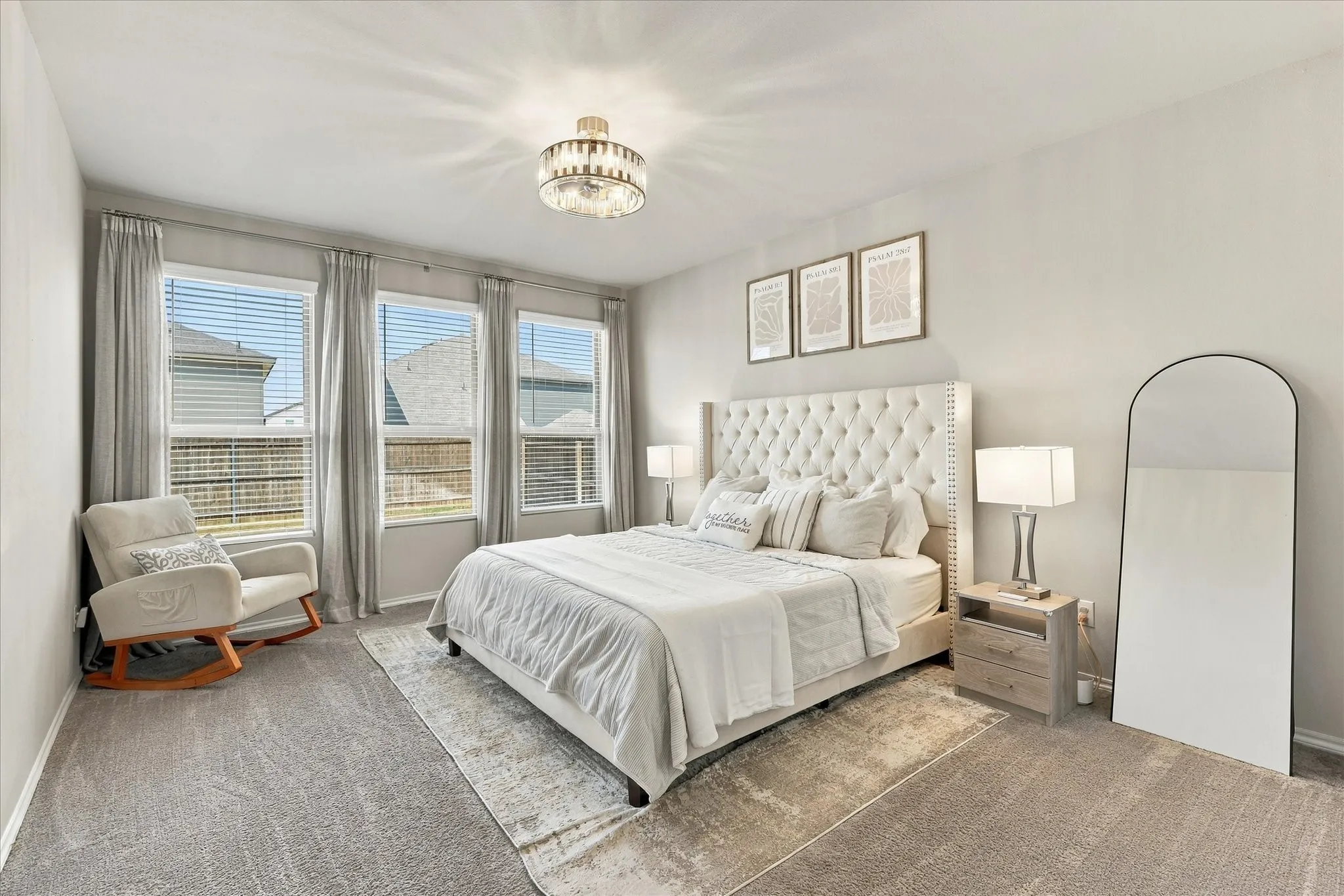 Plush carpet flooring, multiple large windows, and a decorative ceiling light fixture