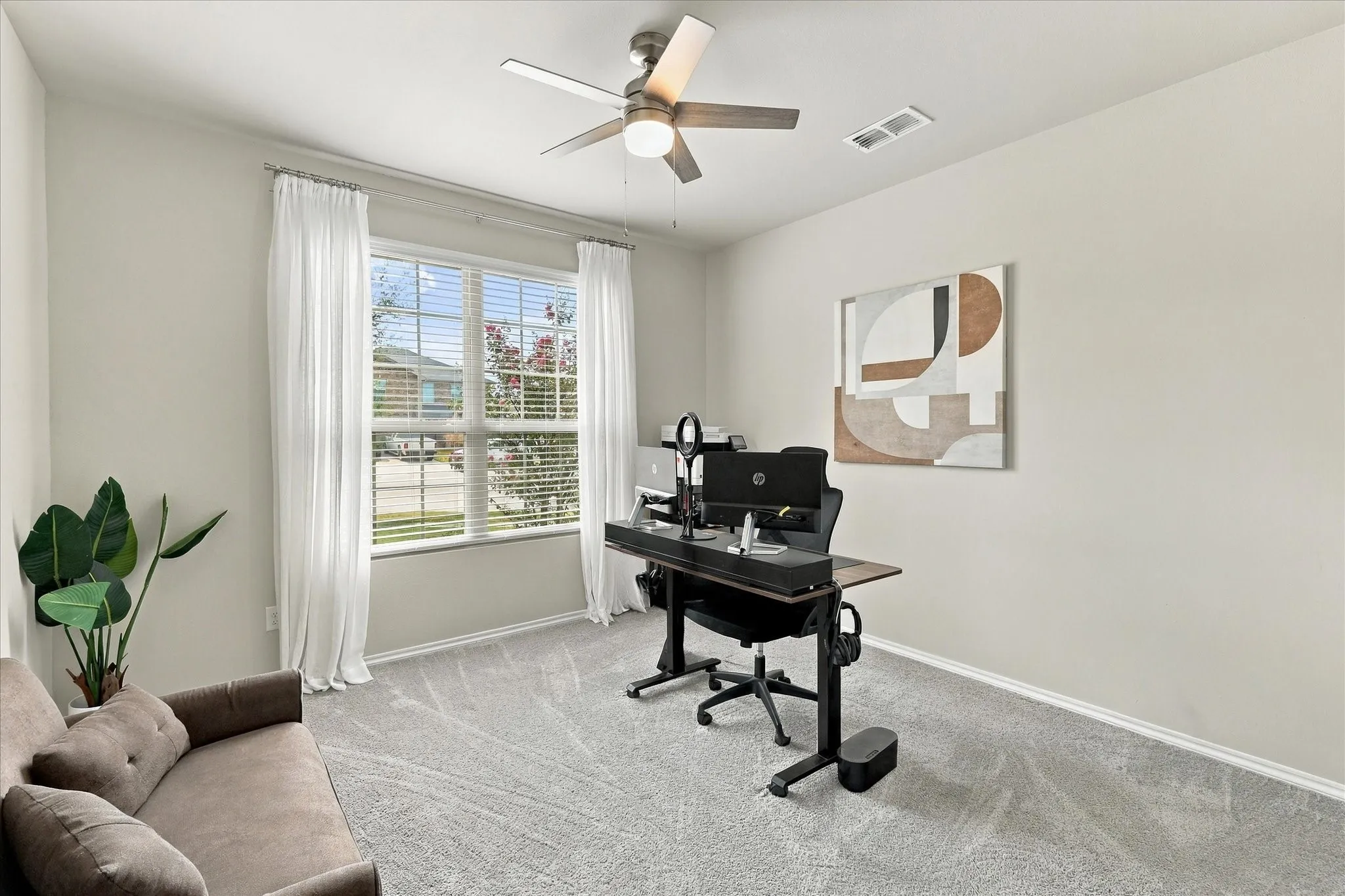 Light-colored walls, window with blinds, ceiling fan, and grey patterned carpet