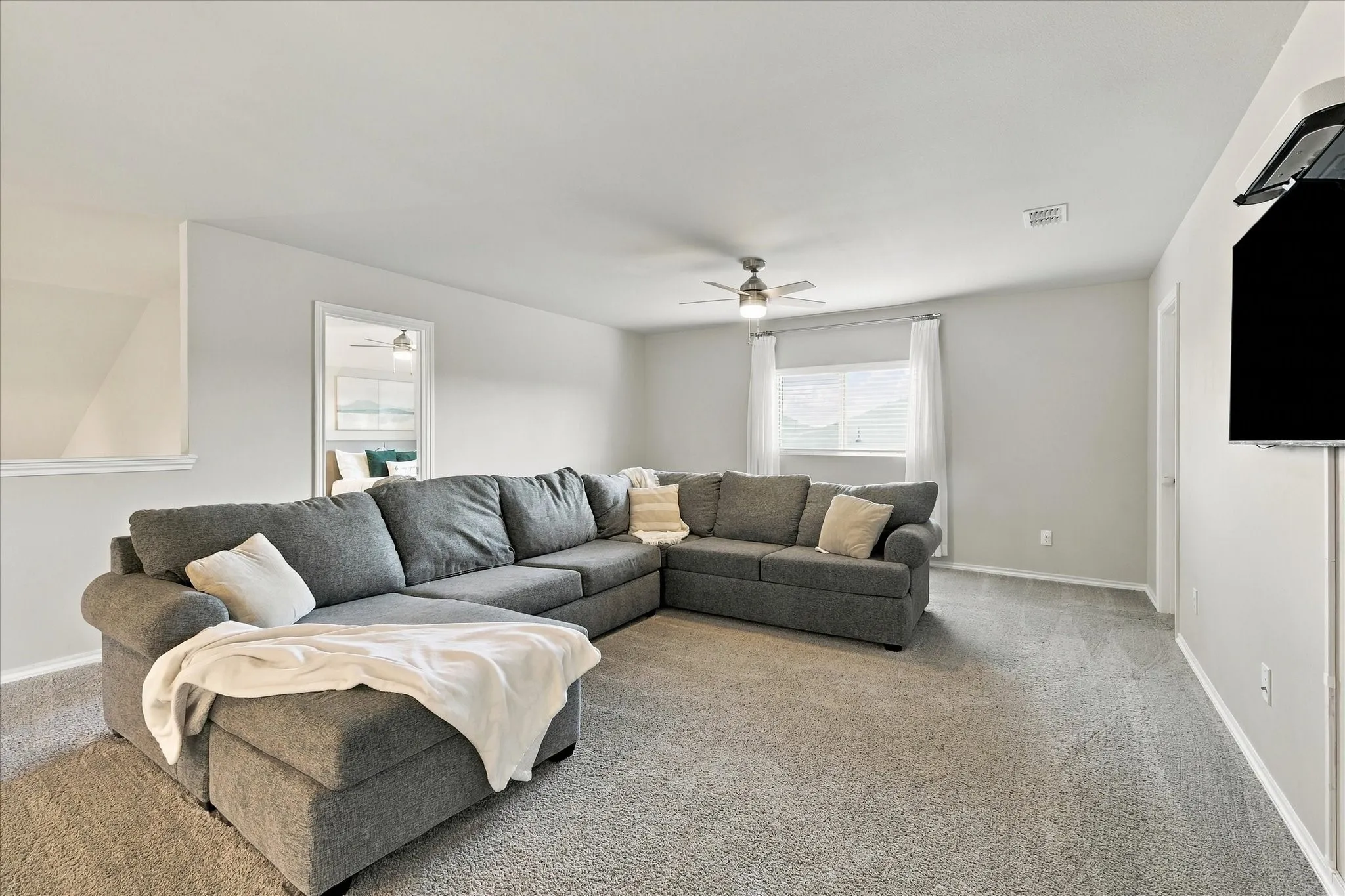 Carpeted flooring, ceiling fan, white window treatments, and light-colored walls