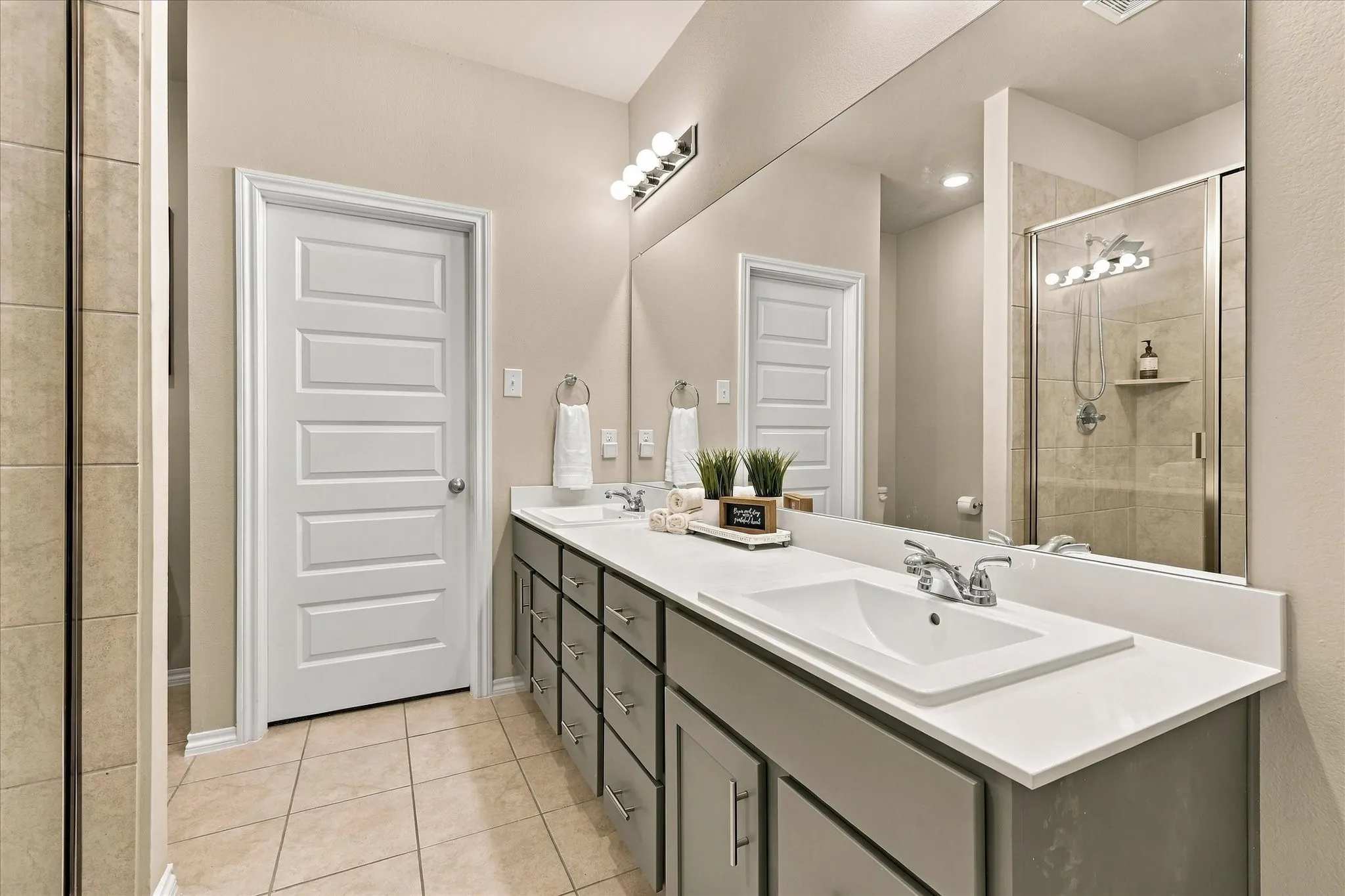 Dual vanity with an expansive counter, full-width mirror, and chrome fixtures