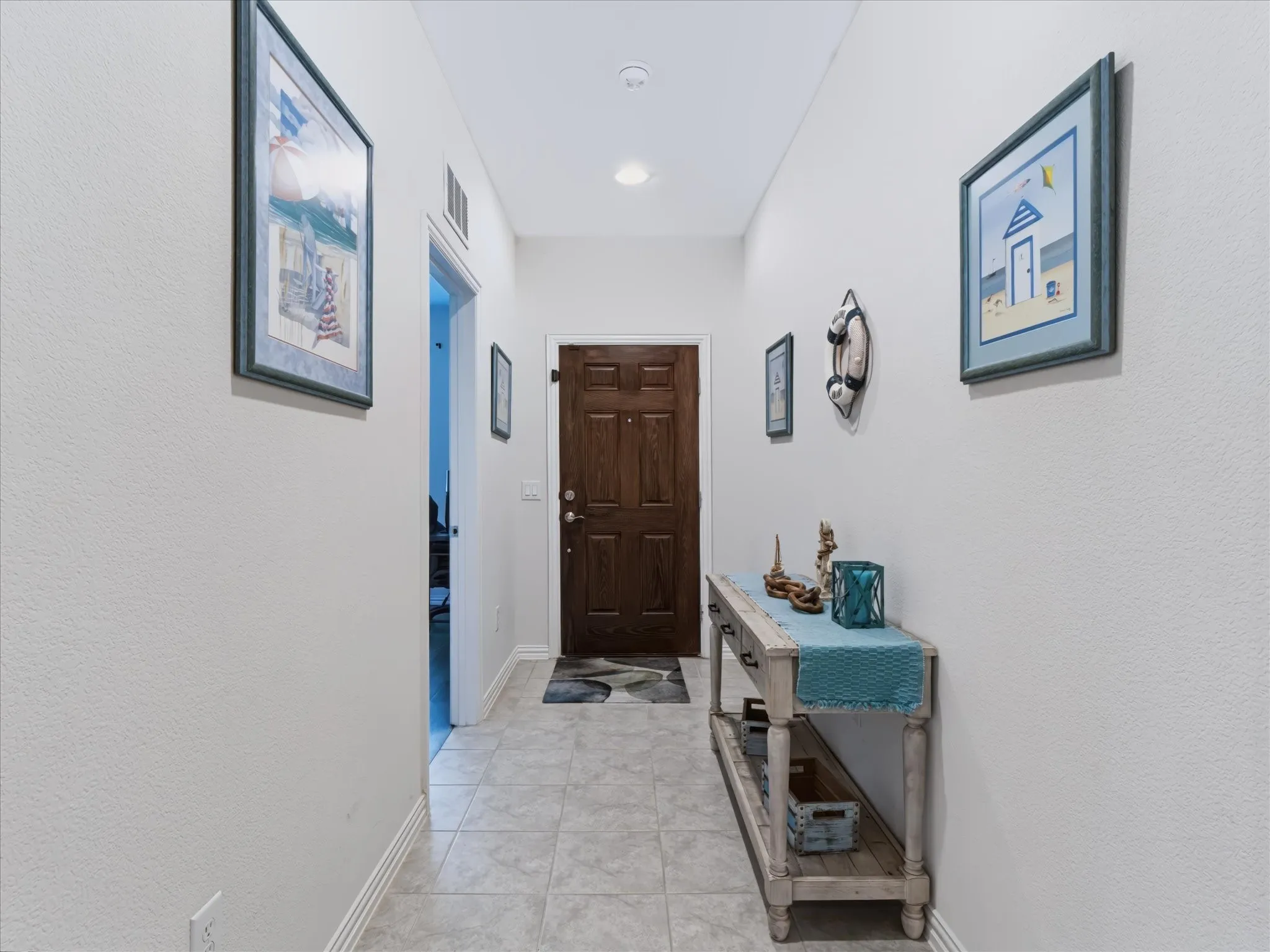 Recessed lighting illuminates a hallway with light-toned wall finishes