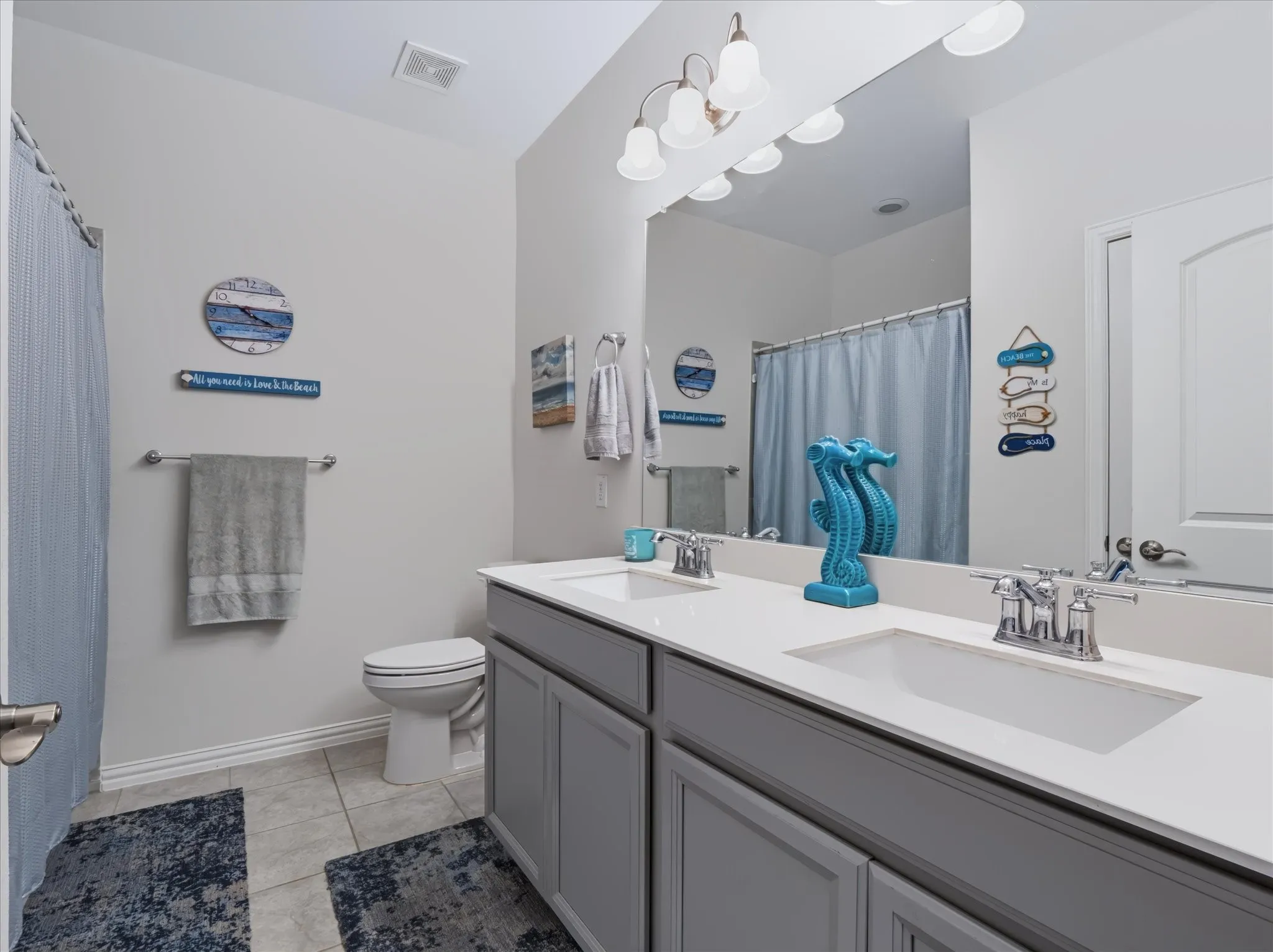Dual vanity with undermount sinks, chrome fixtures, and a spacious mirror
