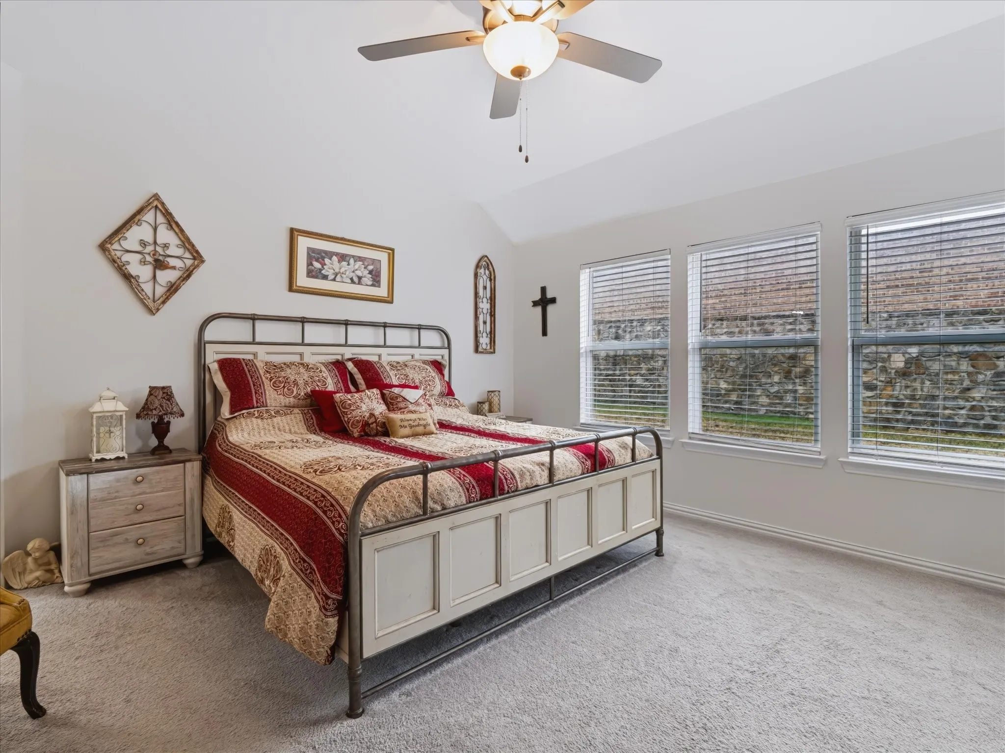 Vaulted ceiling with a ceiling fan, three pane windows, carpeted flooring, and white walls