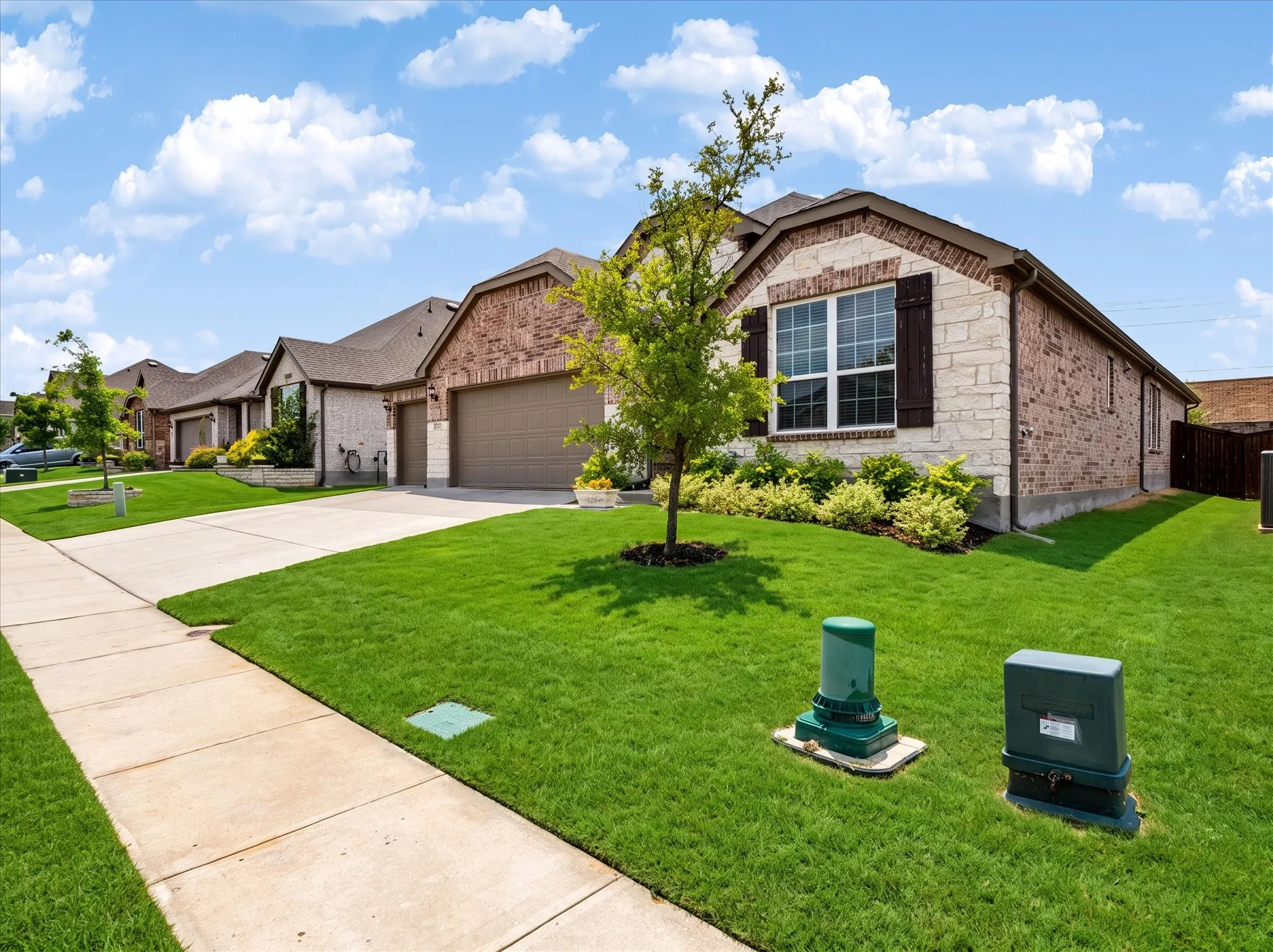 Brick and stone exterior with decorative window shutters.  Digitally enhanced to show green grass.
