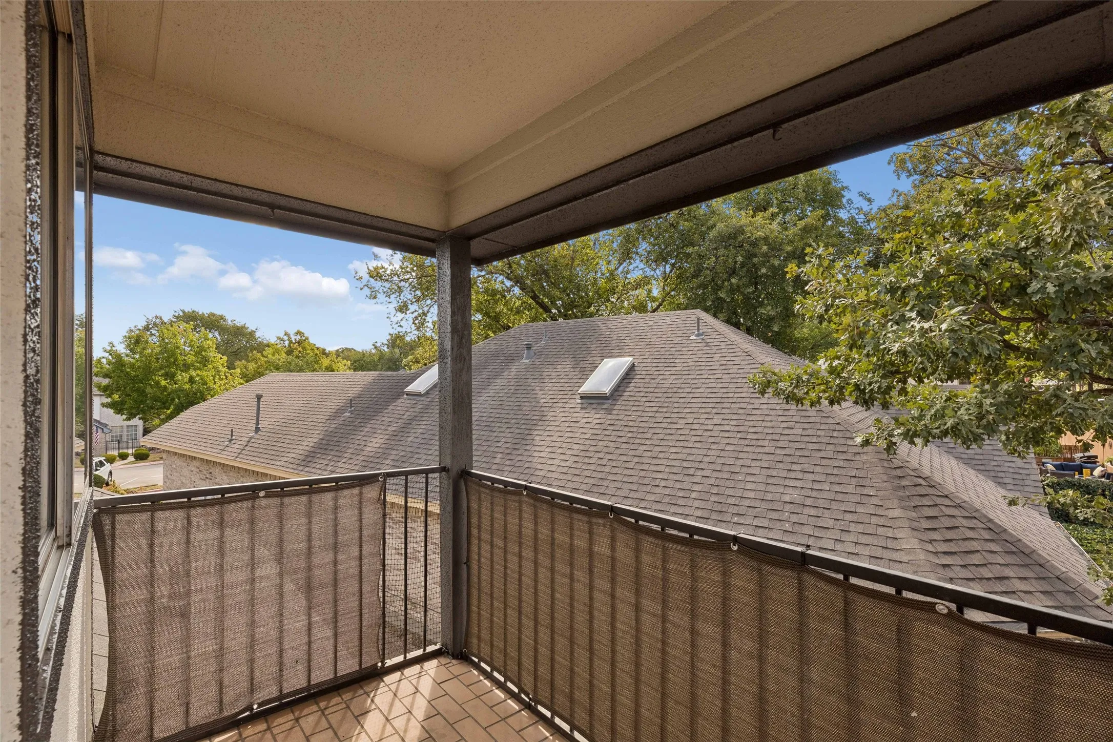 Balcony with brick paver flooring, metal railing, and privacy screening