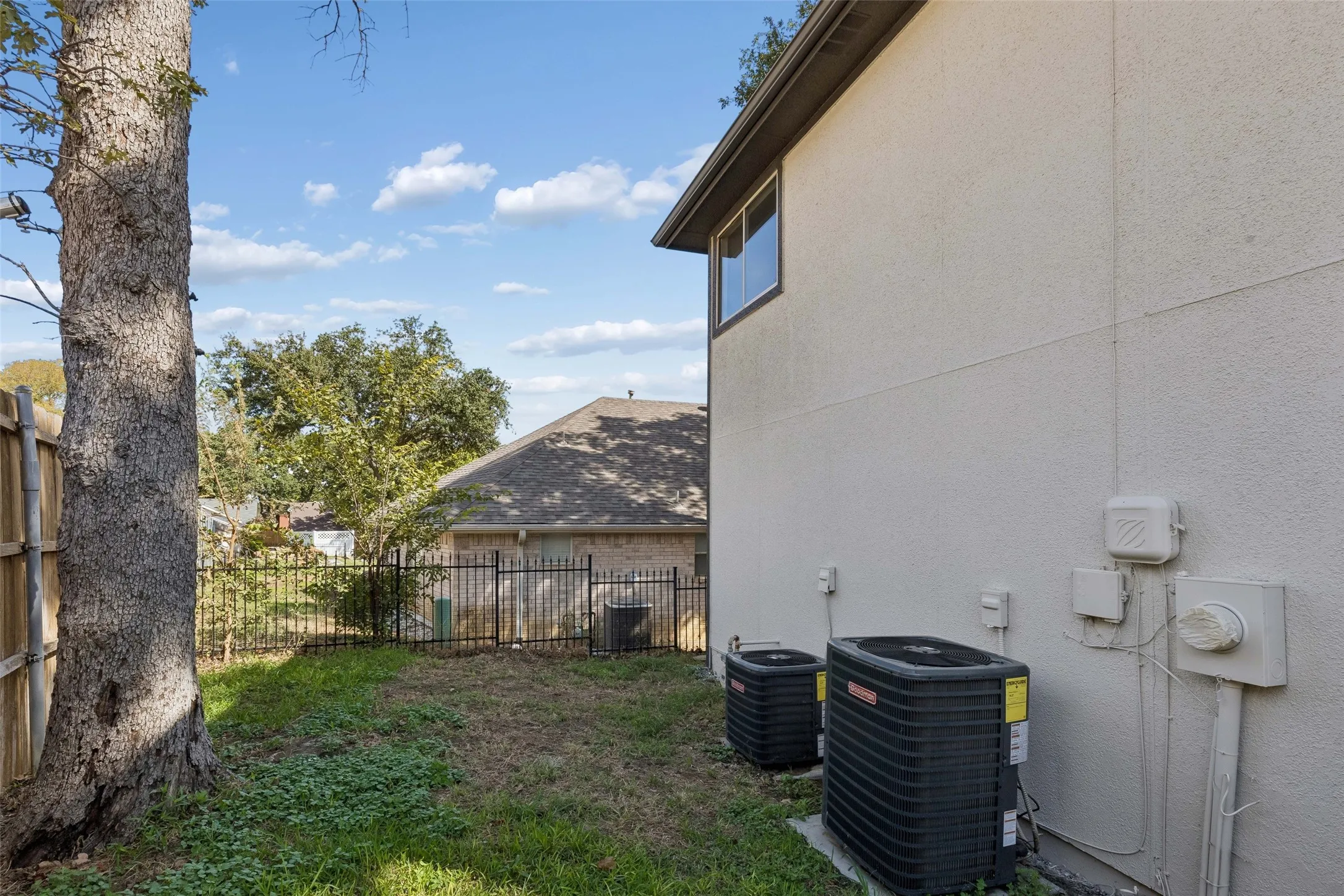 Stucco exterior featuring dual HVAC units and a rear window