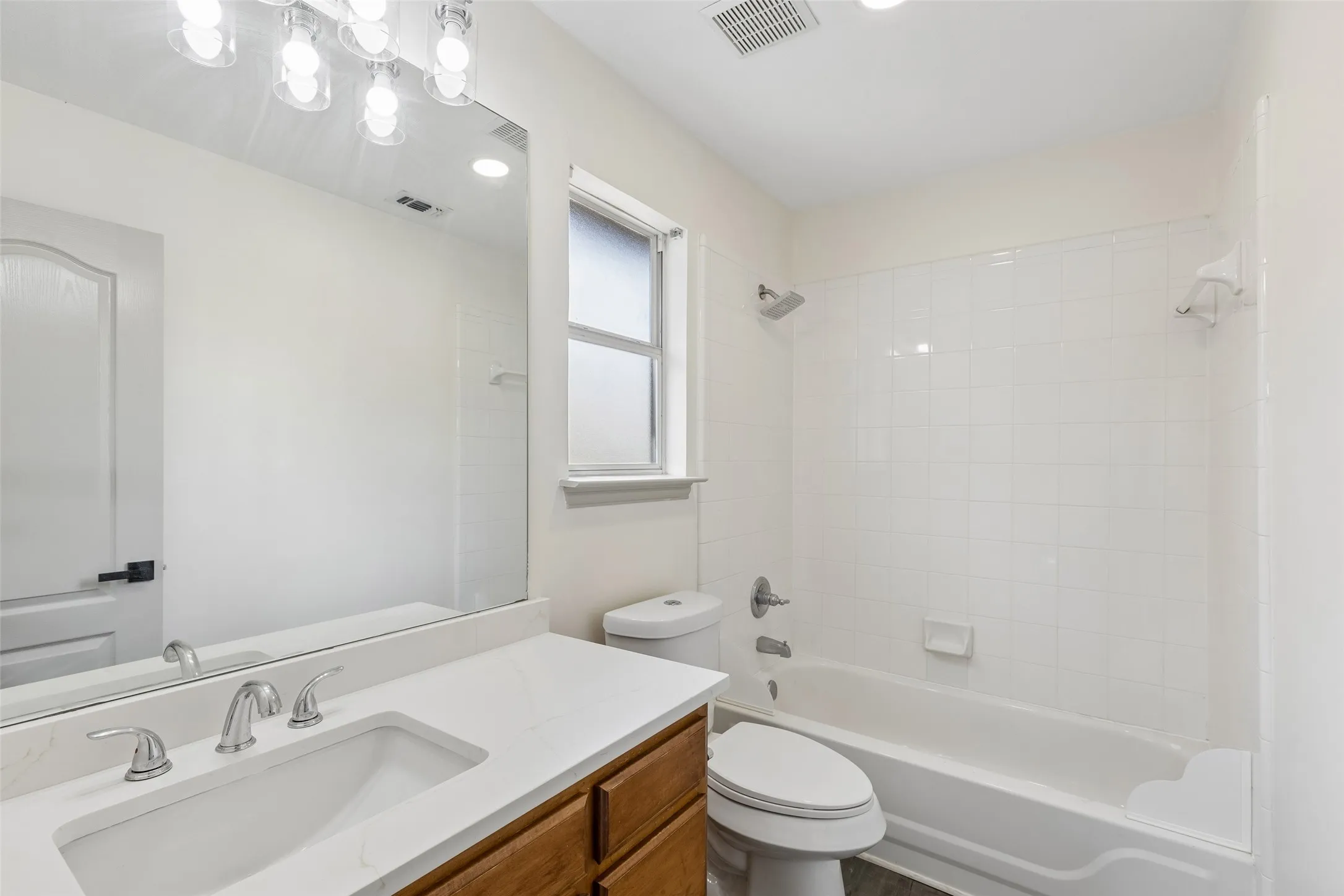 White-tiled bath and shower combination with a built-in soap dish