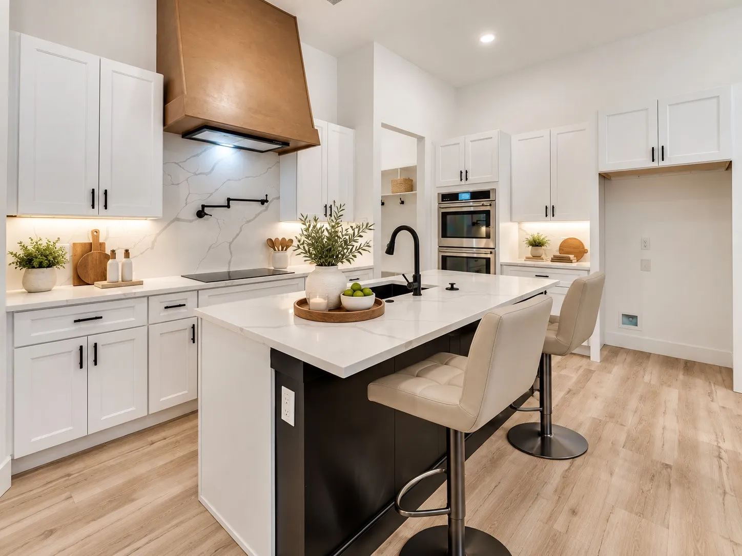 Kitchen featuring white shaker cabinetry, an integrated cooktop, light-toned wood-finish flooring, a contemporary range hood, and a kitchen island with a dark base and light countertop