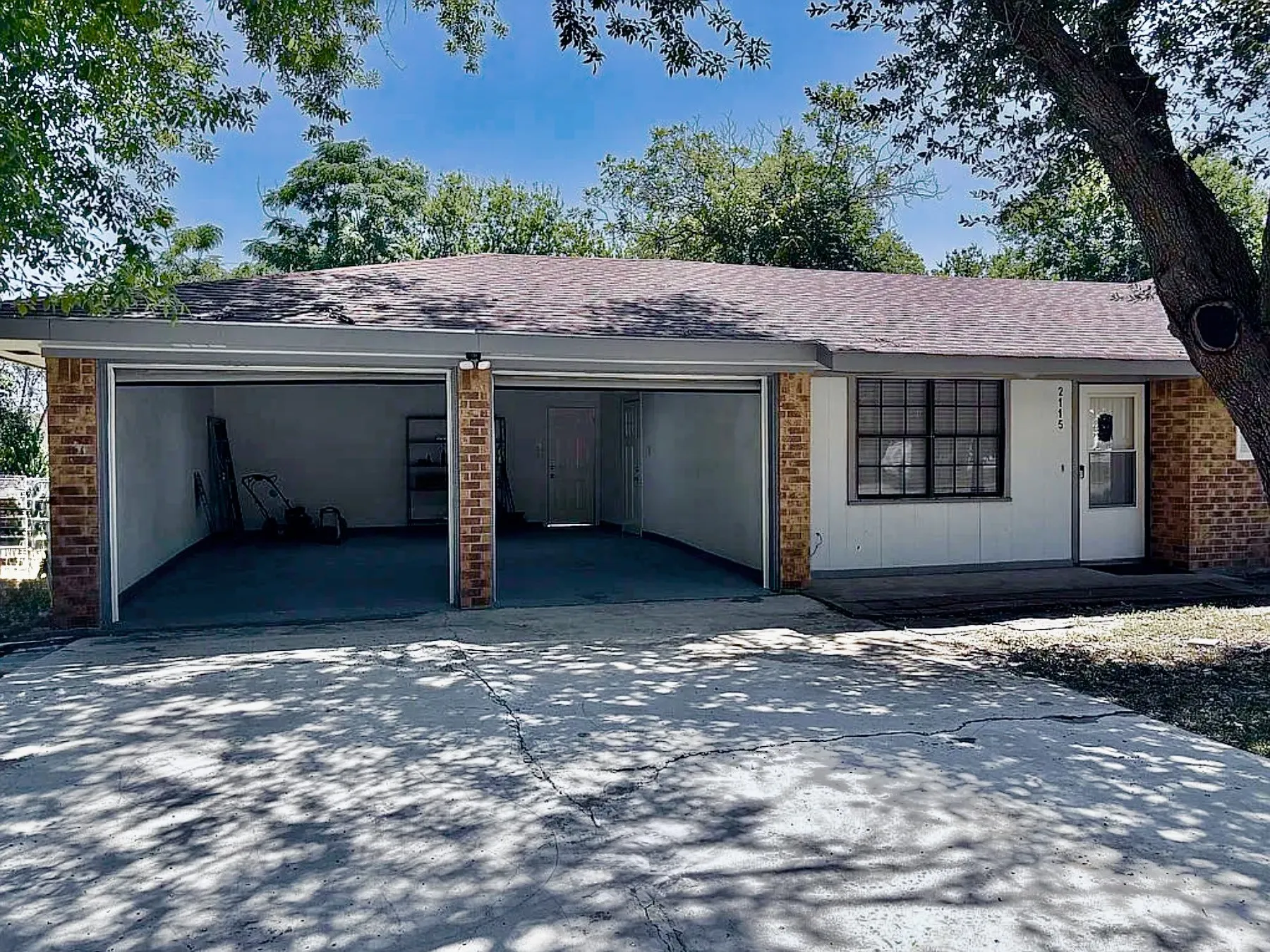 Brick and siding exterior with a two-car garage, concrete driveway, and front entry