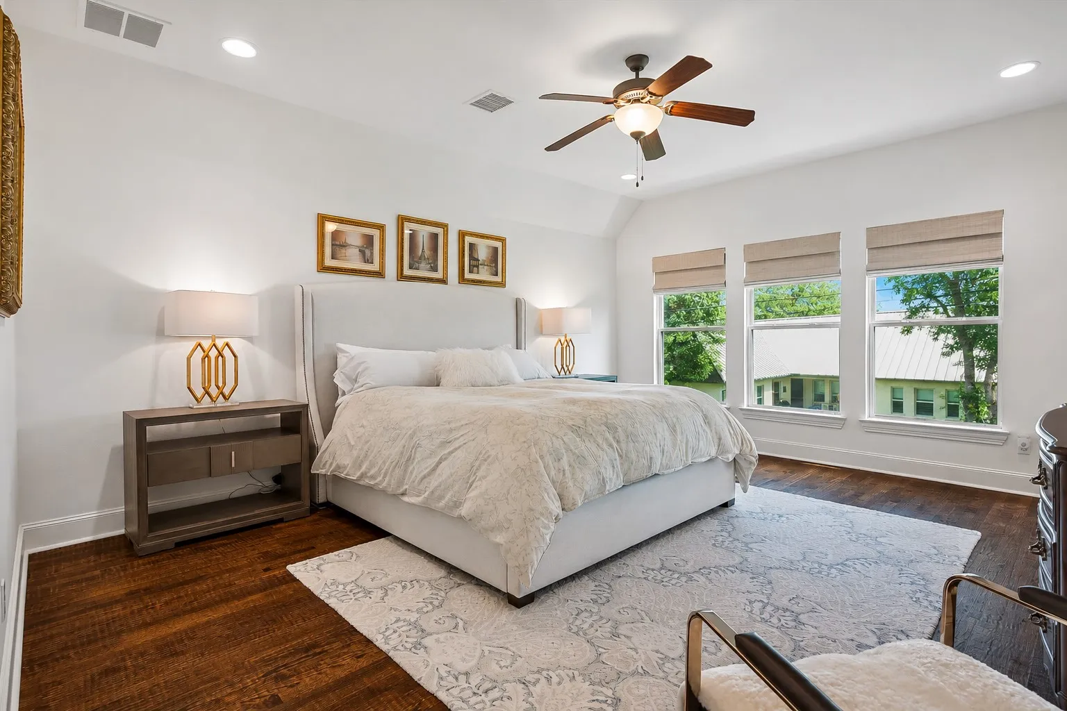 Vaulted ceiling with a ceiling fan, recessed lighting, wood-finish flooring, and multiple windows