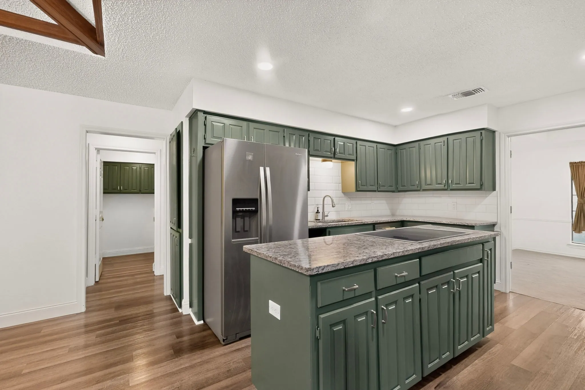 Kitchen featuring wood-finish flooring, recessed lighting, and a stainless steel refrigerator