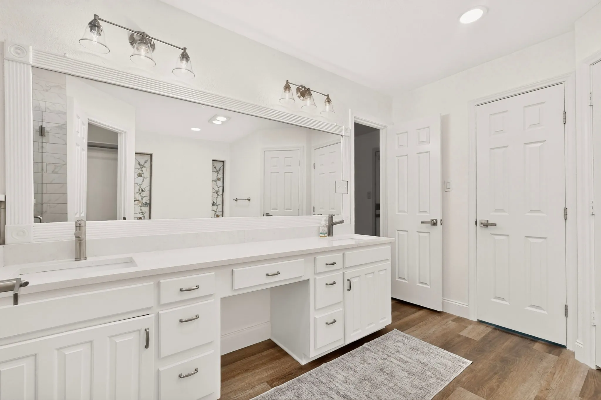 Dual vanity with white cabinetry, integrated sinks, white countertops, and brushed nickel fixtures