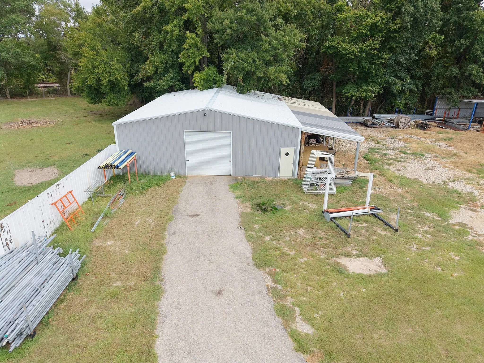 Metal-sided building with a white overhead door and a covered side entrance