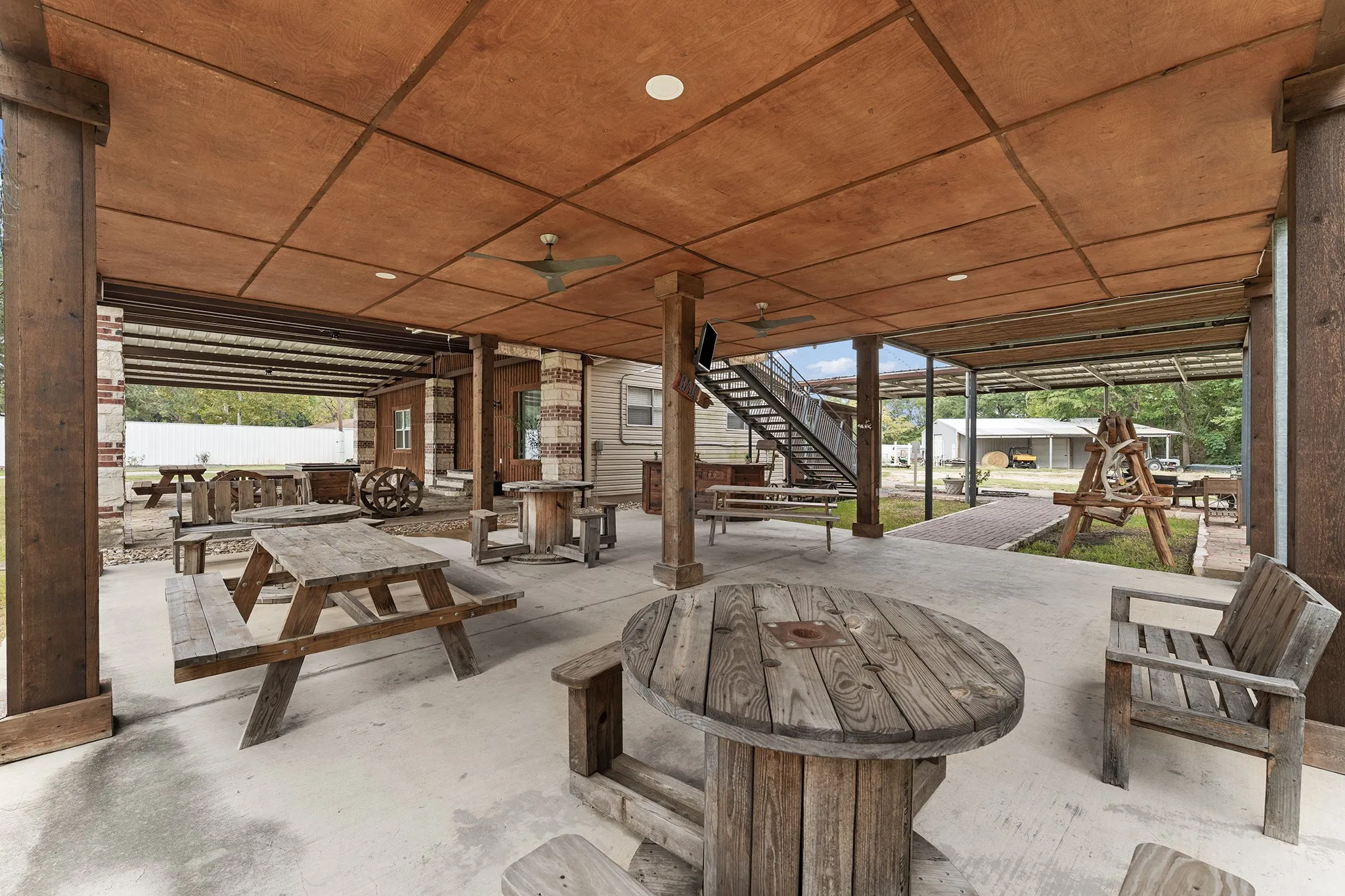 Covered patio with exposed wood-finish ceiling, recessed lighting, ceiling fans, and concrete flooring