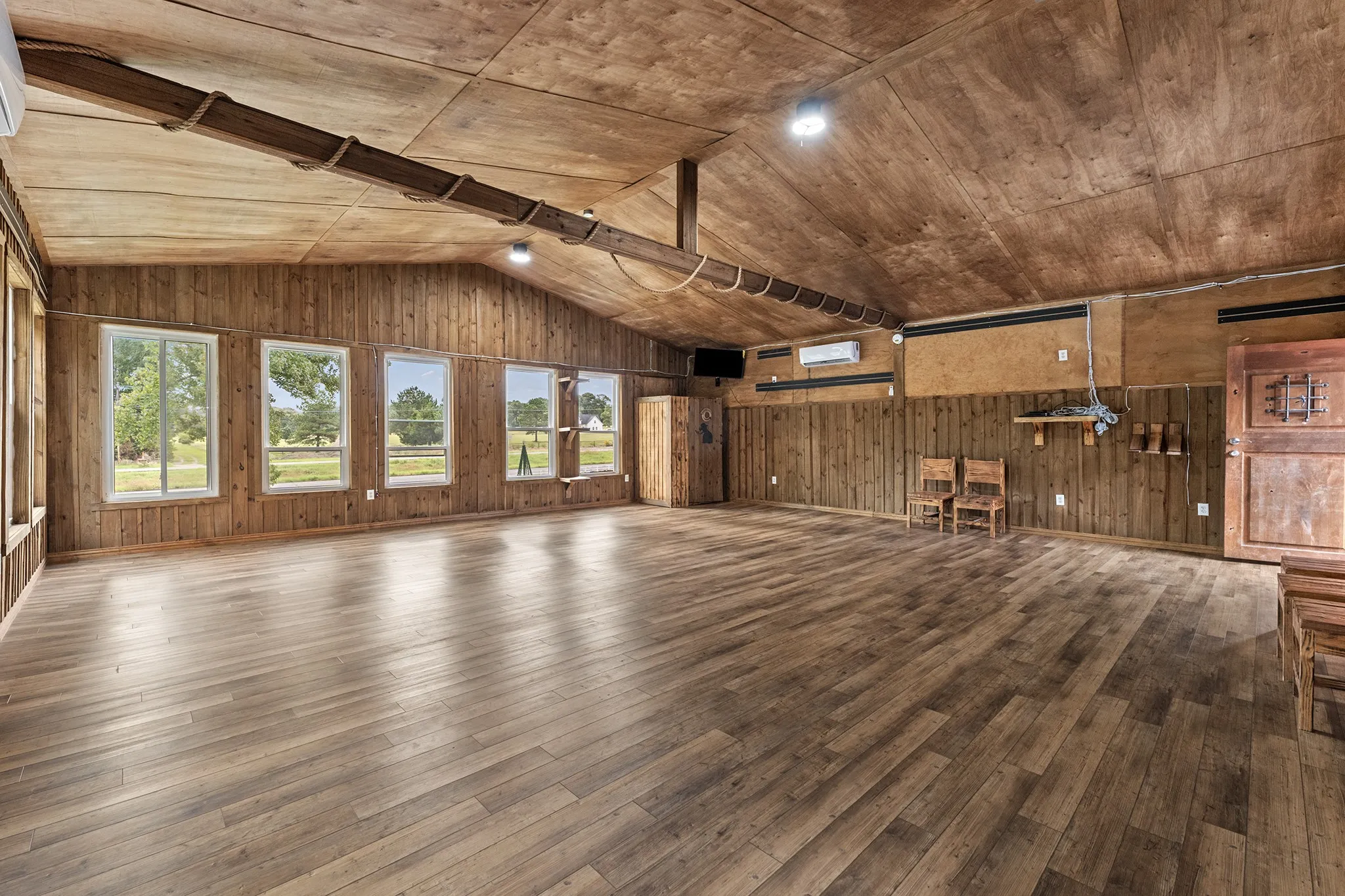 Vaulted wood-finish ceilings, wood-finish flooring, wood paneling, and multiple windows