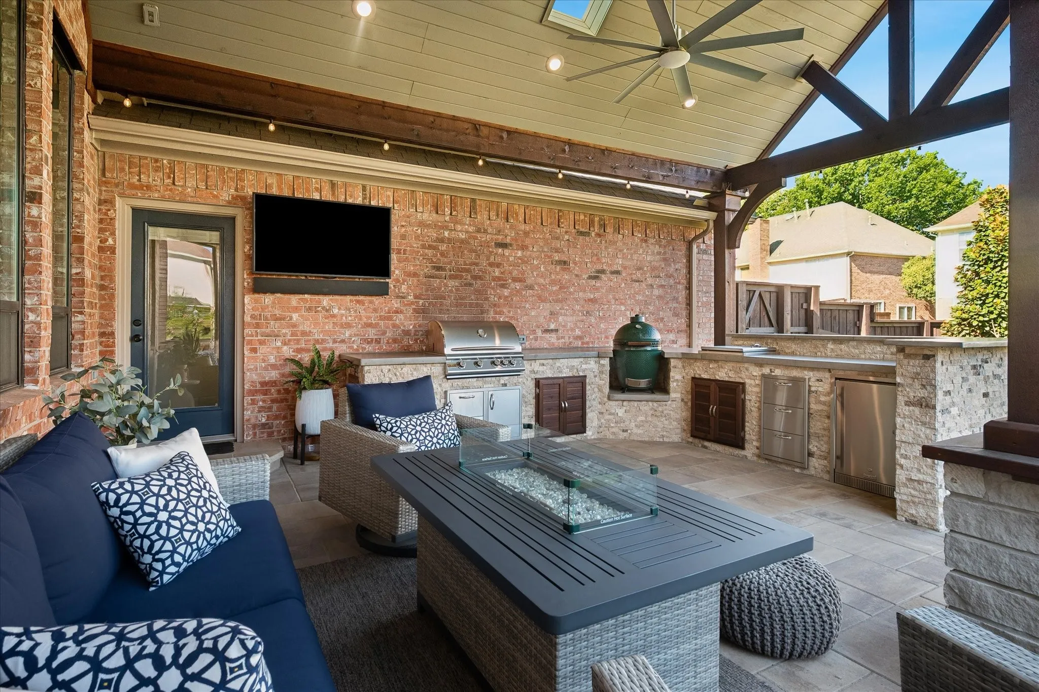 Covered patio featuring a ceiling fan, skylight, built-in outdoor kitchen with stainless steel appliances, and a paver patio surface